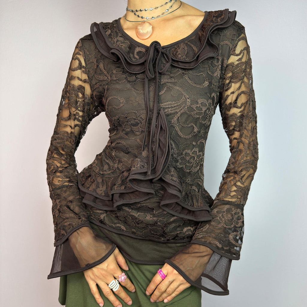 The Y2K Brown Lace Ruffle Top is a vintage 2000s statement piece, showcasing intricate floral lace throughout for a romantic and feminine look. This top features a stretchy semi-sheer fabric, layered ruffles along the neckline. adult world shop