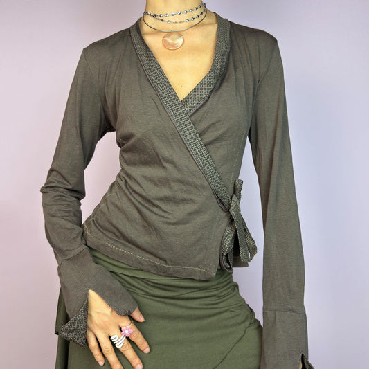 The Y2K Brown Wrap Cop Copine Top is a sleek and minimalist 2000s piece featuring a wrap-tie design with geometric-patterned trim details and flared cuffs. This top is crafted from a stretchy, comfortable fabric. adult world shop