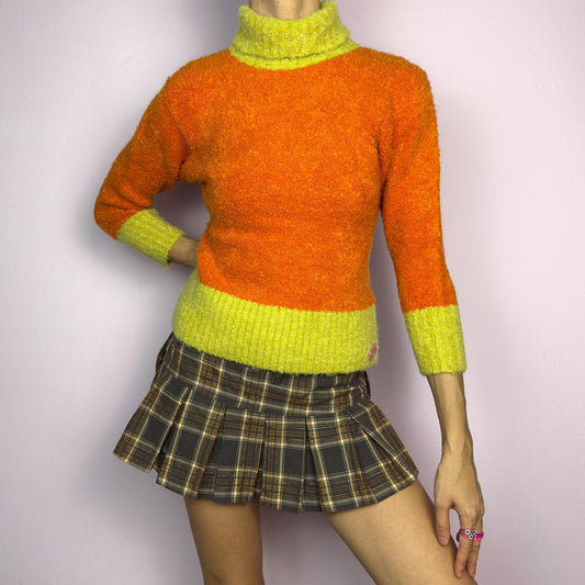 This Y2K Colorblock Fuzzy Turtleneck Sweater is a cozy 2000s piece for winter outfits. Featuring a soft knit in a bold orange and yellow color block design, this sweater combines warmth with a retro aesthetic. It also includes a high turtleneck and three quarter sleeves. adult world shop