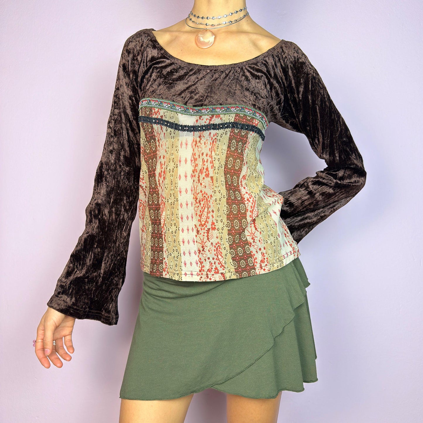 The Y2K Flared Sleeve Mesh Top is a vintage 2000s stretchy piece that combines soft brown velvet bell long sleeves with a printed semi-sheer mesh bodice featuring earthy tones. Perfect for a whimsical inspired look. adult world shop