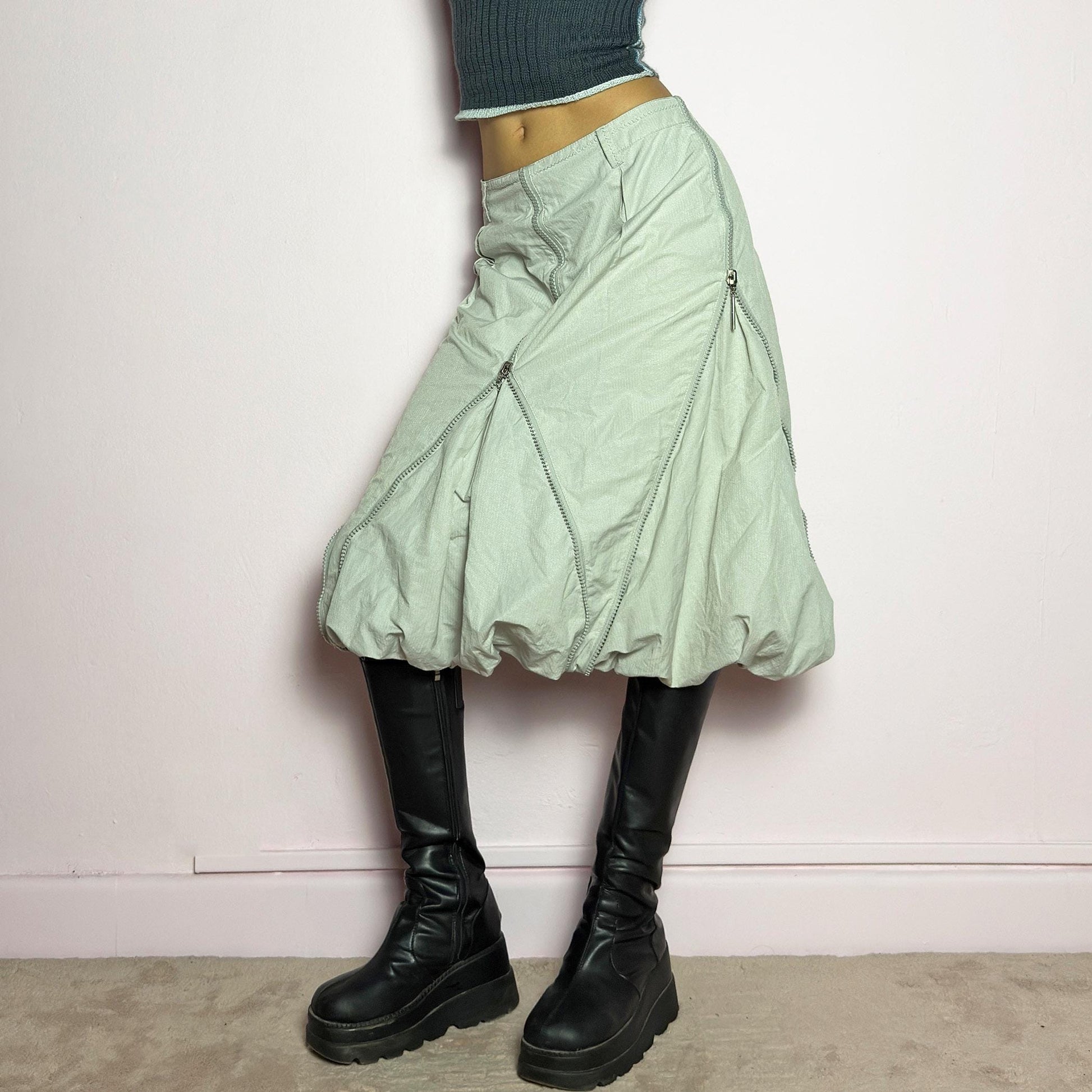 The Y2K Gray Bubble Midi Skirt is a futuristic statement 2000s piece featuring a voluminous bubble silhouette with multiple zipper details that create a dynamic, adjustable shape. Designed with a structured high-rise fit, and a side zipper closure, this skirt is perfect for bold streetwear outfits. adult world shop