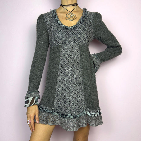 The Y2K Gray Knit Mini Dress is a vintage 2000s piece featuring a patchwork knit design with ruffle trim details. With a fitted bust and flared hem, this dress has a romantic and whimsical aesthetic. The long sleeves add a cozy. adult world shop