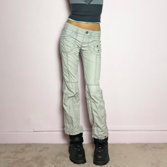 The Y2K Gray Low-Rise Pants are a vintage 2000s piece featuring a lightweight, structured fabric with a washed gray tone. Designed with a low-rise waist, button and zipper closure, and pockets, these pants offer a cropped, relaxed straight-leg fit with contrast stitching and panel detailing for a utilitarian-inspired aesthetic. Perfect for streetwear and casual grunge looks. adult world shop