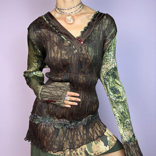 The Y2K Lace Asymmetric Layered Top is a vintage 2000s piece featuring an earthy mix of brown and green tones with a textured, stretchy fabric. This unique top showcases a V-neckline adorned with delicate lace trim, button details. adult world shop