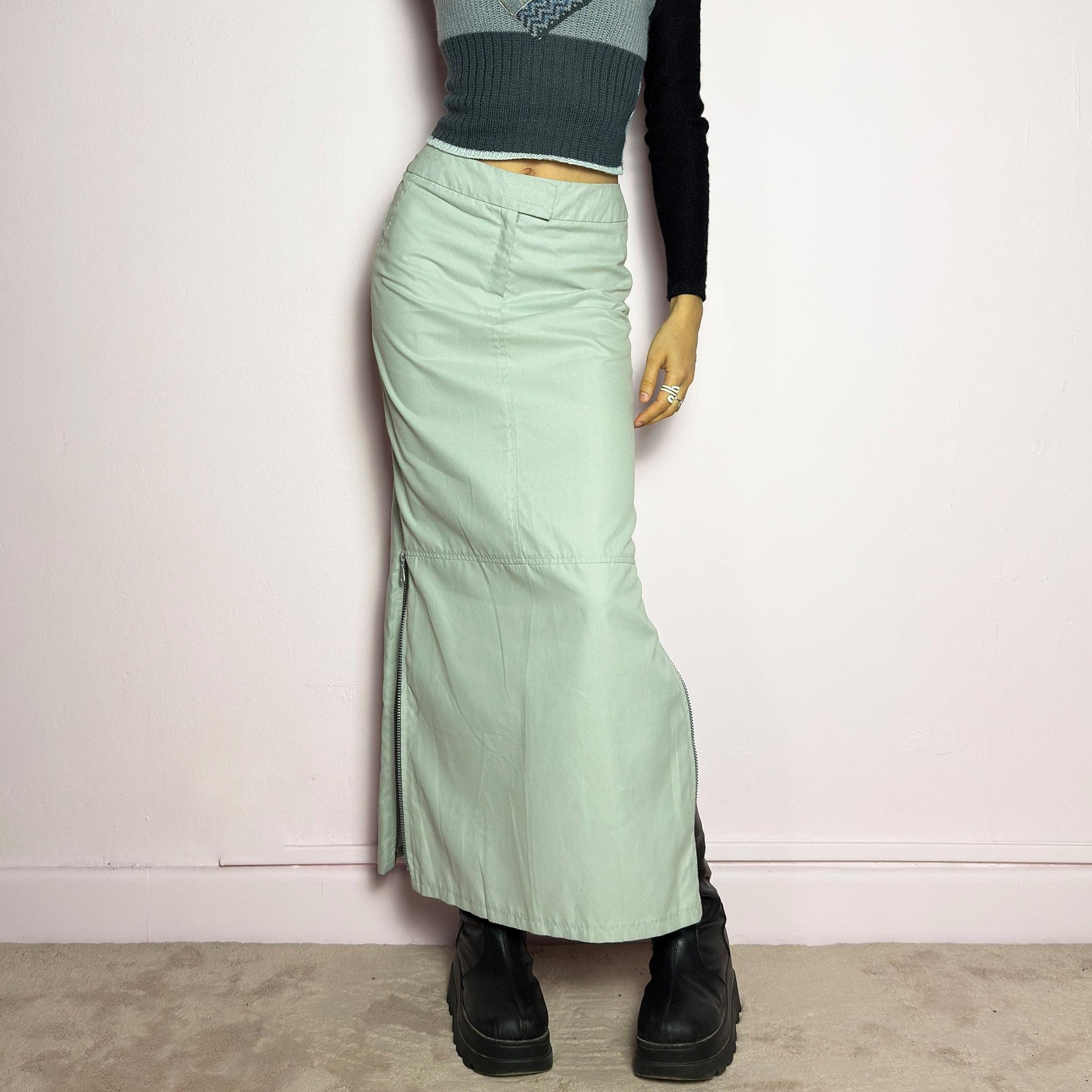 The Y2K Light Gray Maxi Skirt is a vintage 2000s piece with a sleek, futuristic aesthetic. Featuring a structured fit, and a high-rise waist, this skirt is designed for a modern, minimal look. Made from lightweight fabric, it offers a flattering silhouette with dual side zipper slits for adjustable styling. Perfect for casual, streetwear, or cyber-inspired avant-garde outfits. adult world shop