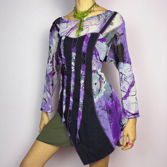 The Y2K Mesh Asymmetric Black Top is a vintage 2000s piece featuring a semi-sheer mesh fabric with an abstract purple, black, and white print. Designed with three quarter sleeves and contrast paneling and exposed seams, this top has a deconstructed, edgy aesthetic. The asymmetric hem and raw cut details add a unique touch, making it perfect for grunge or fairycore-inspired outfits. Lightweight and stretchy, ideal for layering and statement looks. adult world shop