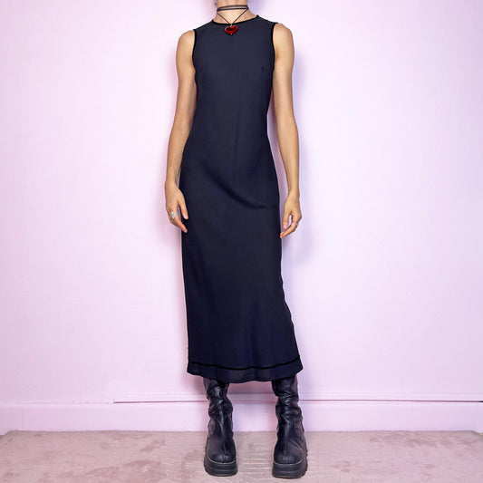 The Y2K Minimalist Black Midi Dress is a vintage 2000s sleek and timeless piece featuring a sleeveless design, and a slim, flattering fit. Crafted with lightweight, slightly sheer fabric, it drapes beautifully along the body and ends in a classic midi length. Features a back zipper closure and a back slit for ease of movement and an elegant touch. Perfect for minimalist, officecore, or elegant 90s-inspired looks. Effortlessly versatile for both casual layering and dressier night-out outfits.