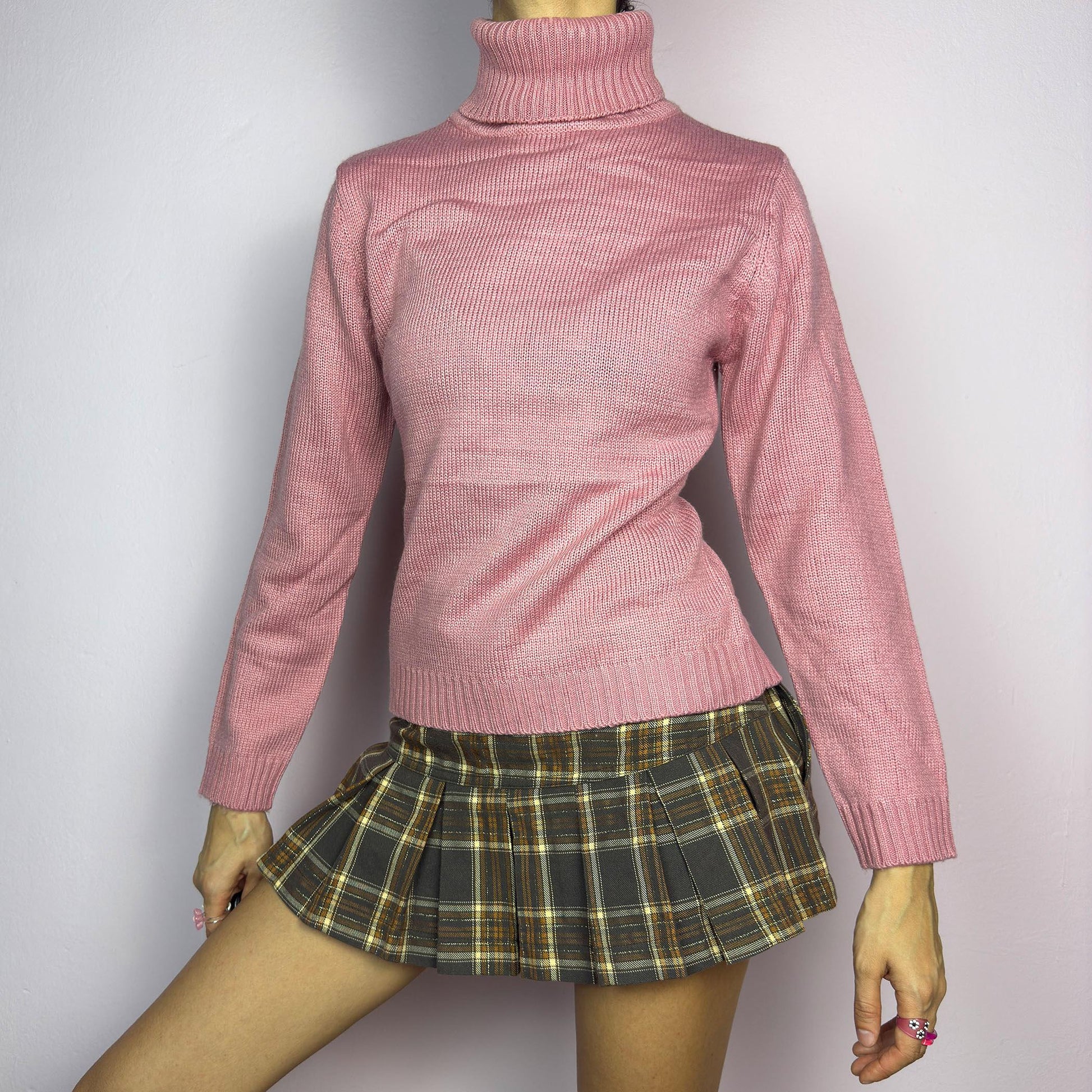 This Y2K Pink Turtleneck Sweater is a cozy 2000s essential with a minimalist vintage aesthetic. Crafted from a soft, knit fabric in a muted pastel pink, it features a classic high turtleneck, a fitted silhouette for a flattering look and long sleeves with ribbed cuffs. Ideal for casual or preppy winter styles. adult world shop