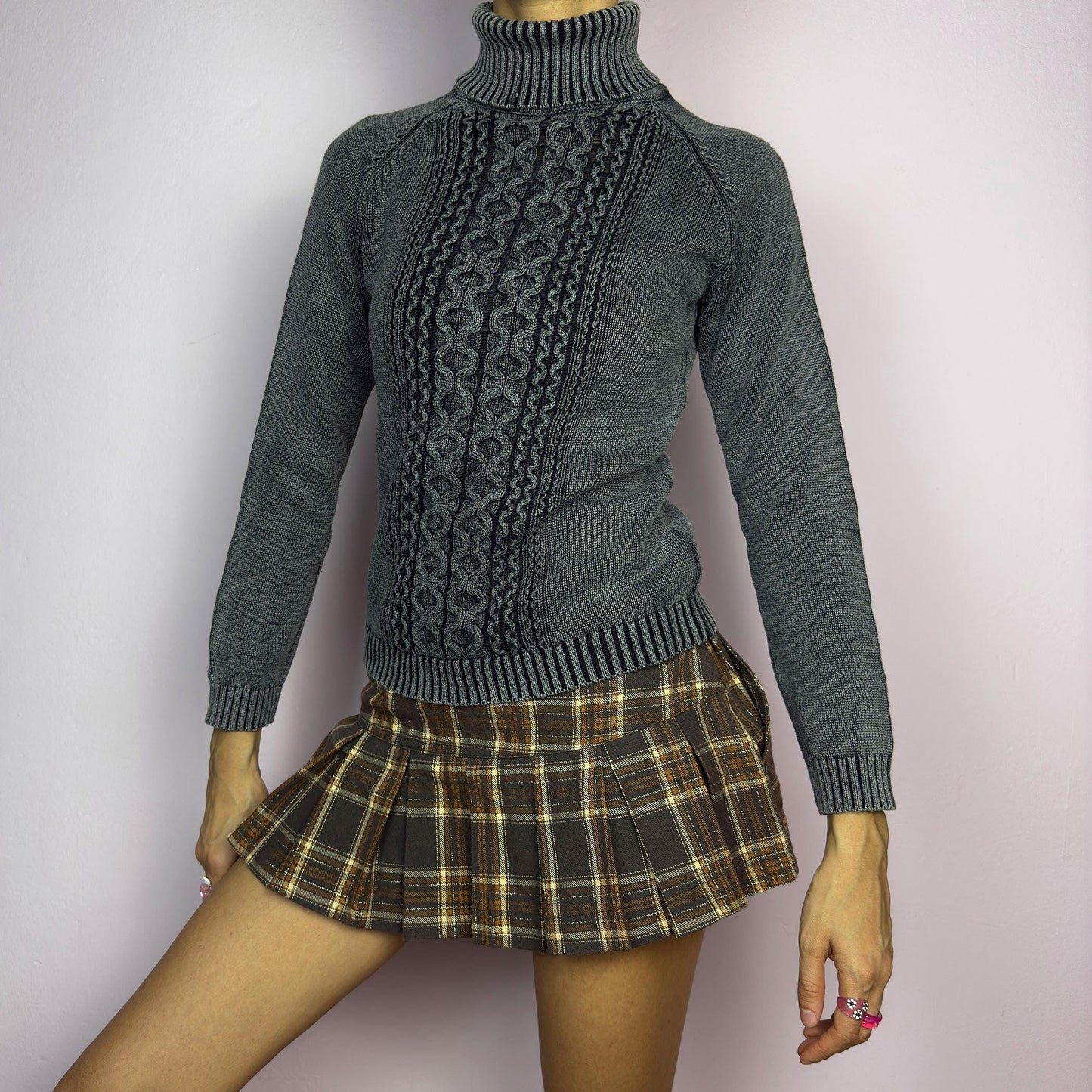 The Y2K Washed Gray Turtleneck Sweater is a vintage 2000s piece, featuring a slightly faded gray tone for a worn-in, effortless look. Designed with an intricate cable knit pattern on the front, ribbed cuffs, and a thick turtleneck, it offers both warmth and style. Ideal for preppy, academia, or casual winter outfits. adult world shop