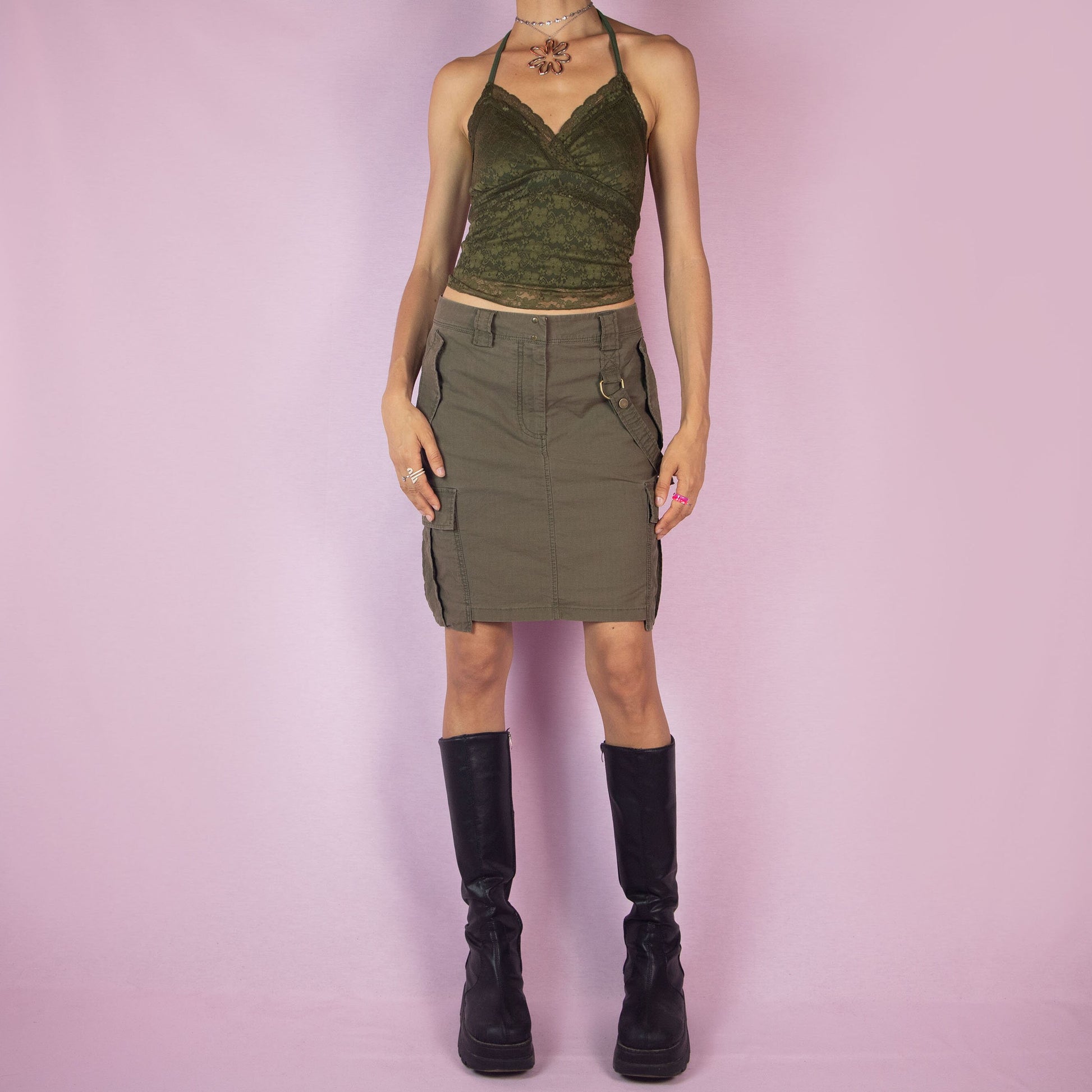 The Y2K Diesel Khaki Cargo Skirt is a vintage 2000s green mini skirt featuring a military-inspired design with multiple pockets, belt loops, and a front zipper closure.