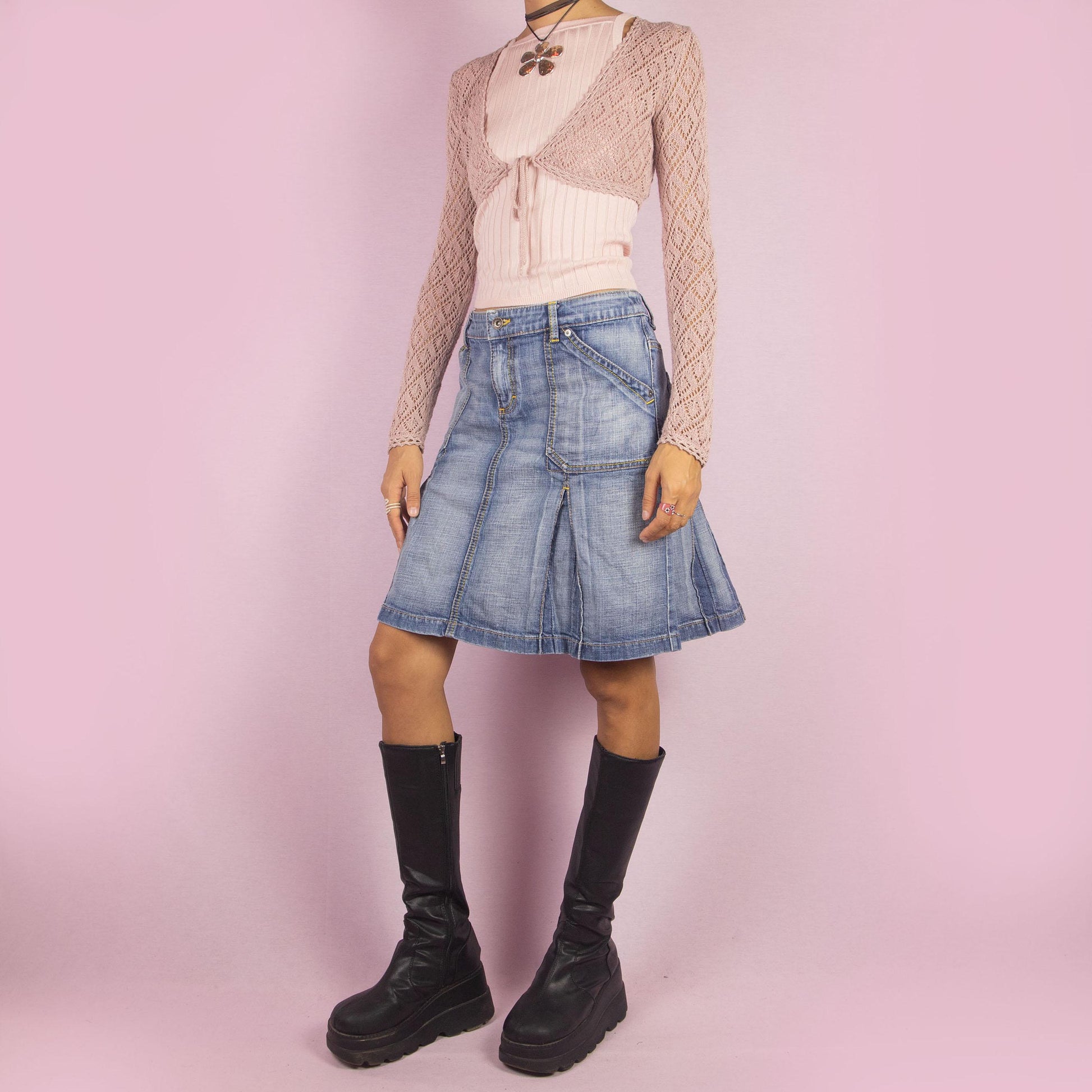 The Y2K Denim Paneled Pleated Skirt is a vintage 2000s piece combining a paneled design with stitched pleats for a structured silhouette. Featuring pockets and a button-and-zipper front closure, this skirt is ideal for casual everyday looks.