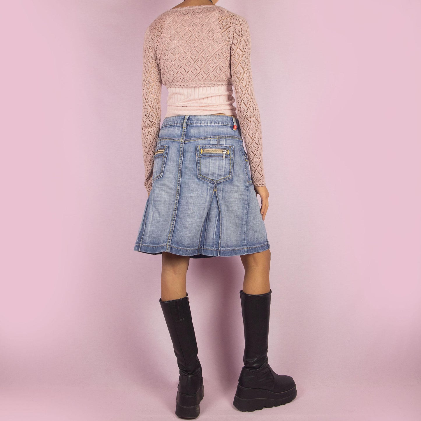 The Y2K Denim Paneled Pleated Skirt is a vintage 2000s piece combining a paneled design with stitched pleats for a structured silhouette. Featuring pockets and a button-and-zipper front closure, this skirt is ideal for casual everyday looks.