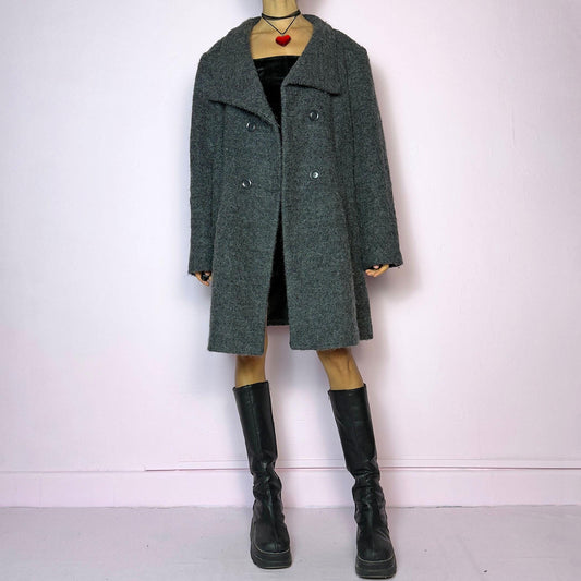The Y2K Gray Wool Coat is a vintage 2000s timeless piece crafted from a soft and warm wool and polyester blend. It features a double-breasted front with oversized buttons, a wide lapel collar, and side pockets for a cozy design. Its relaxed fit
