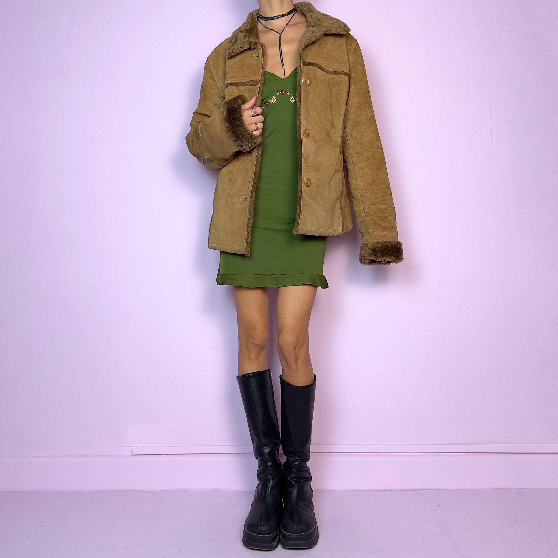 The Vintage 90s Brown Shearling Leather Jacket is crafted from genuine leather with a plush shearling interior for exceptional warmth and comfort. Featuring button closures, fur-lined cuffs, and a cozy collar