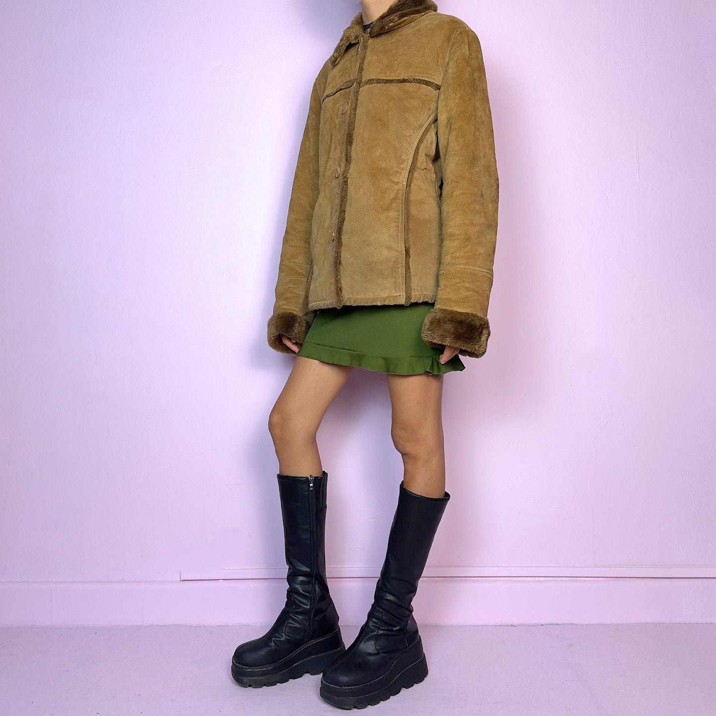 The Vintage 90s Brown Shearling Leather Jacket is crafted from genuine leather with a plush shearling interior for exceptional warmth and comfort. Featuring button closures, fur-lined cuffs, and a cozy collar