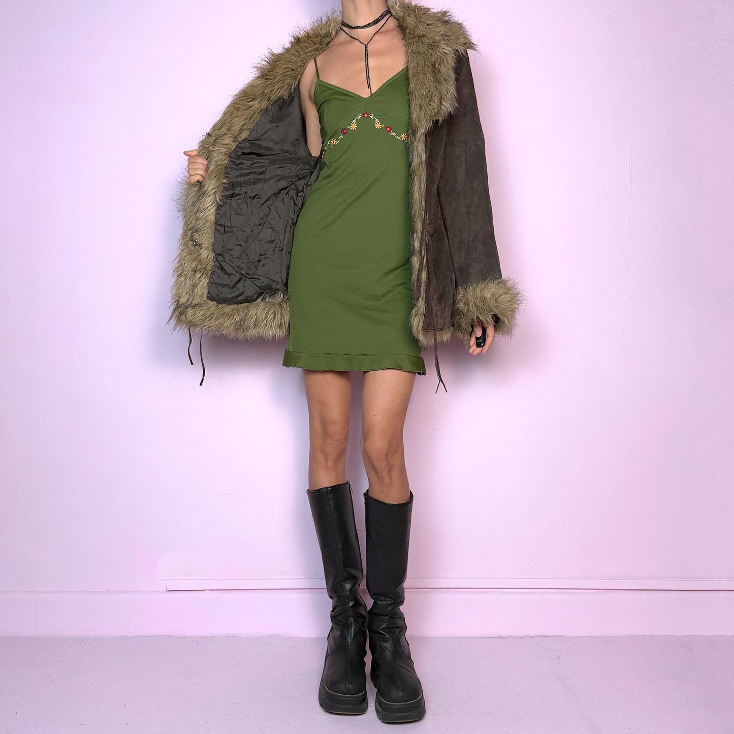 The Vintage 90s Brown Suede Penny Lane Jacket features a brown leather suede exterior and plush faux fur trim on the collar, cuffs, and hemline. Featuring tie-front closures for a snug fit and a flattering silhouette