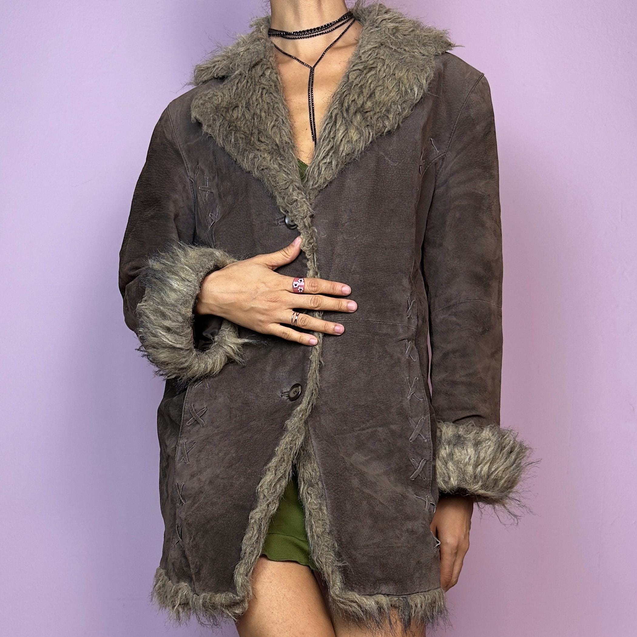 The Vintage 90s Brown Suede Penny Lane Coat showcases a brown leather suede finish paired with soft faux fur trims along the collar, cuffs, and hemline. This jacket features button closures and intricate stitch details. Its timeless design