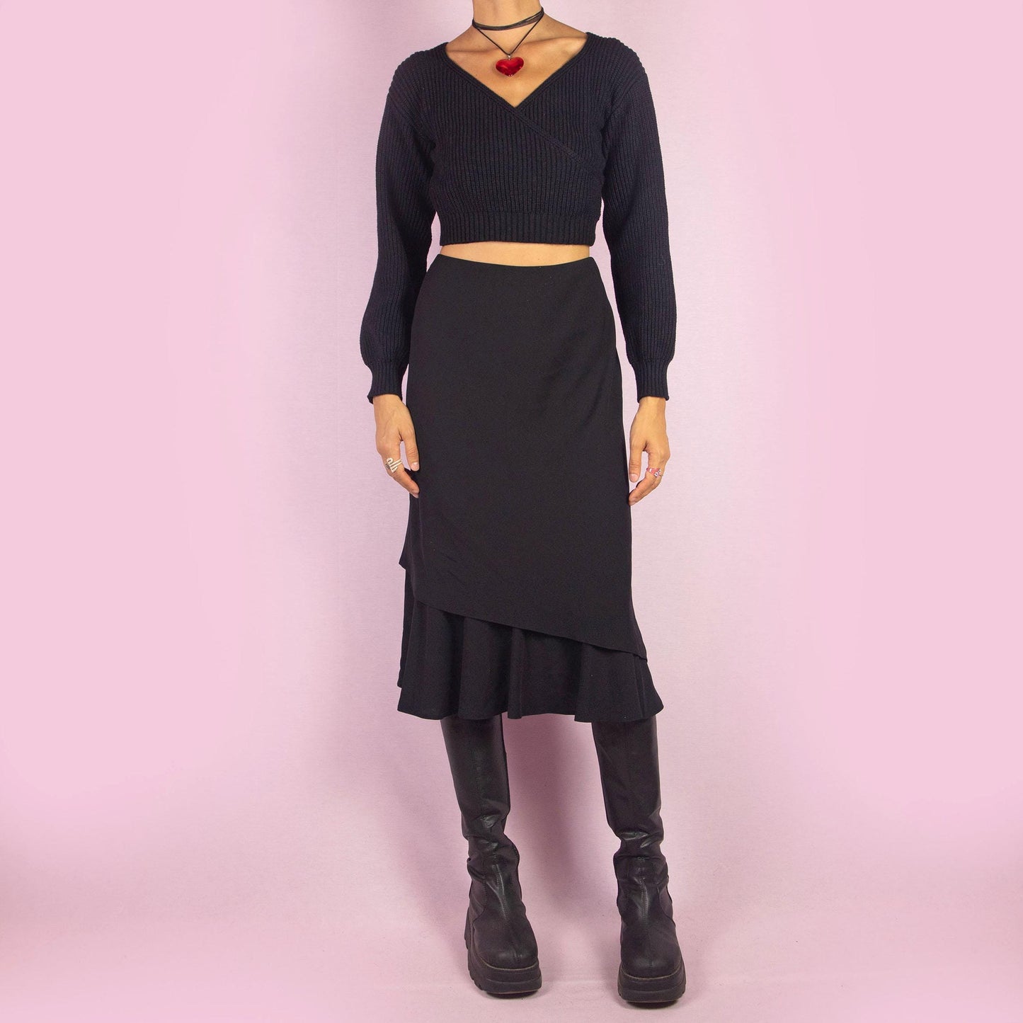 The Vintage 90s Black Layered Midi Skirt showcases a layered design with a flared underlayer peeking out for an elegant silhouette. Featuring an elastic waist, this midi-length skirt is perfect for both office wear and evening occasions.