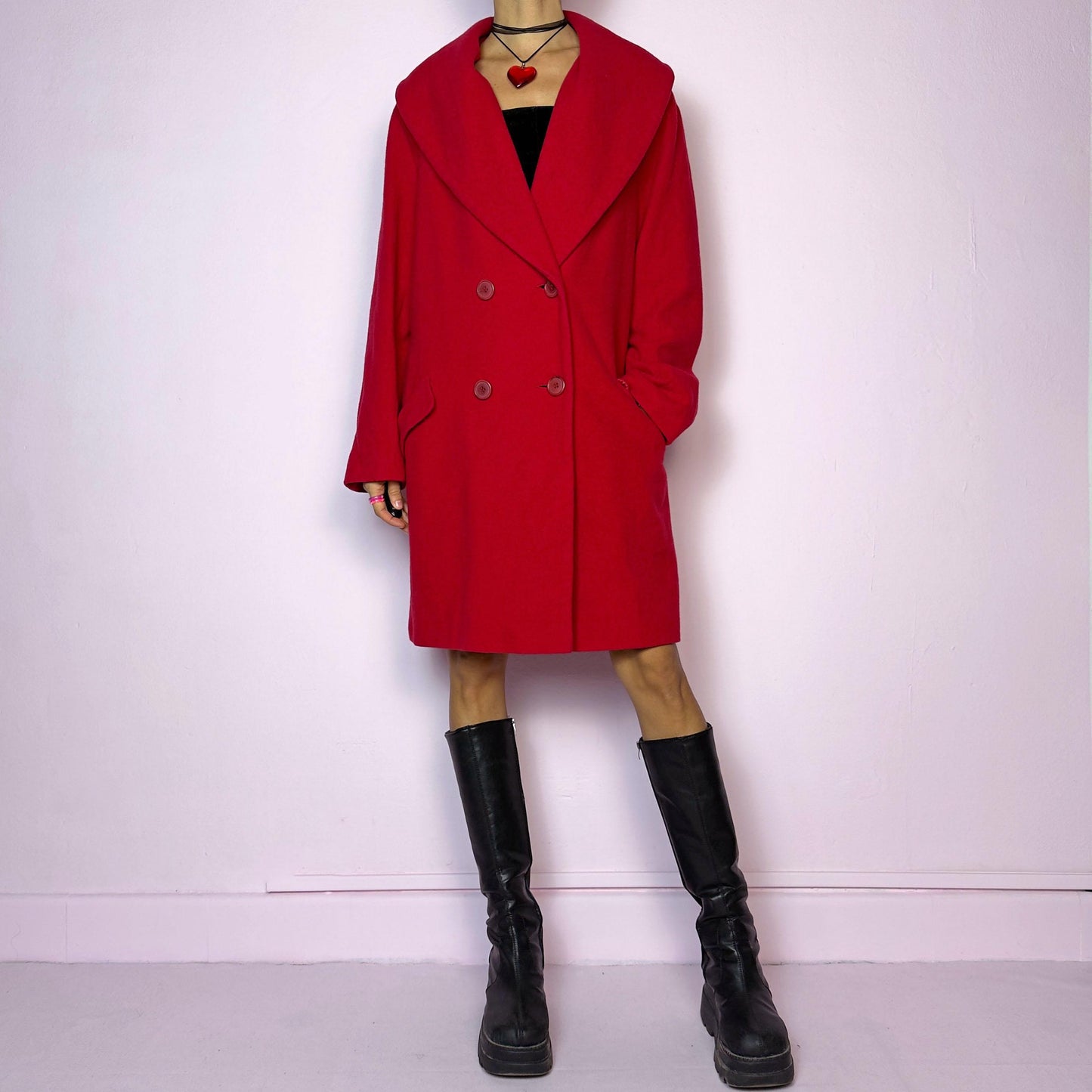 The Y2K Red Wool Coat is a vintage 2000s jacket featuring an oversized design with a shawl collar, double-breasted button closure and pockets. Made from a blend of virgin wool, cashmere, and other fibers, this statement piece is perfect