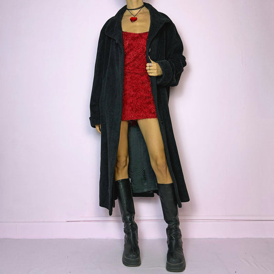 The Vintage 90s Gray Lambswool Maxi Coat features a dark gray, almost black, lambswool and angora blend, offering softness and warmth. It includes pockets and a button front closure. The long silhouette ensures a comfy and cozy fit