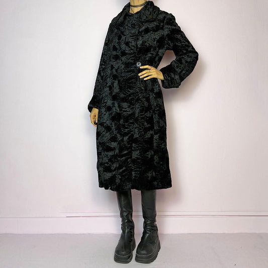 The Vintage 90s Black Faux Fur Long Coat features a plush faux fur exterior for a cozy feel. Designed with a button front closure, it includes long sleeves and pockets. Its longline silhouette makes it a chic and warm choice for winter evenings
