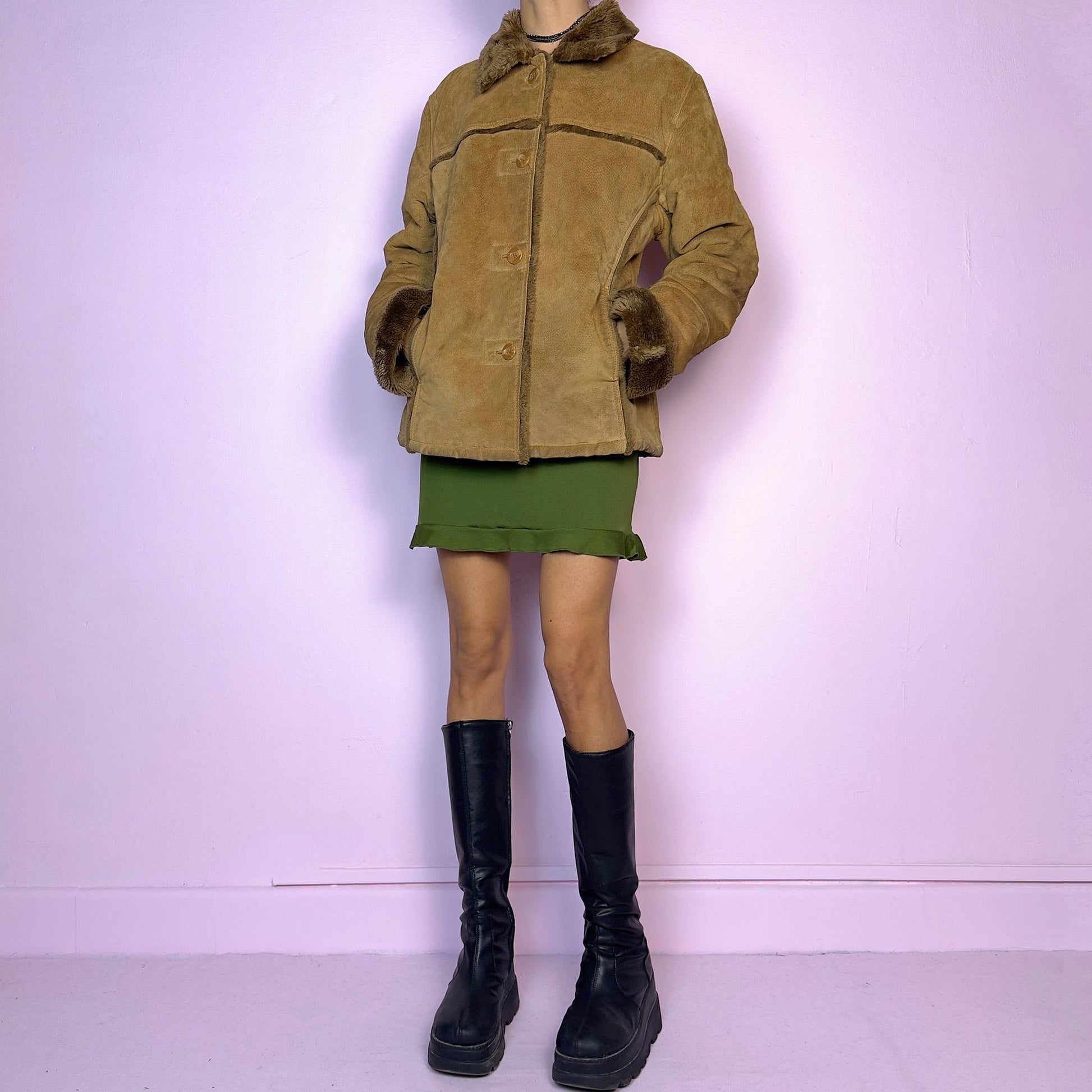 The Vintage 90s Brown Shearling Leather Jacket is crafted from genuine leather with a plush shearling interior for exceptional warmth and comfort. Featuring button closures, fur-lined cuffs, and a cozy collar
