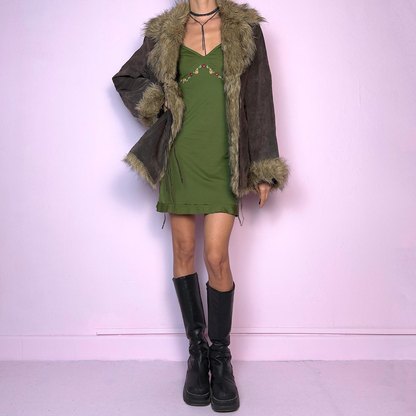 The Vintage 90s Brown Suede Penny Lane Jacket features a brown leather suede exterior and plush faux fur trim on the collar, cuffs, and hemline. Featuring tie-front closures for a snug fit and a flattering silhouette