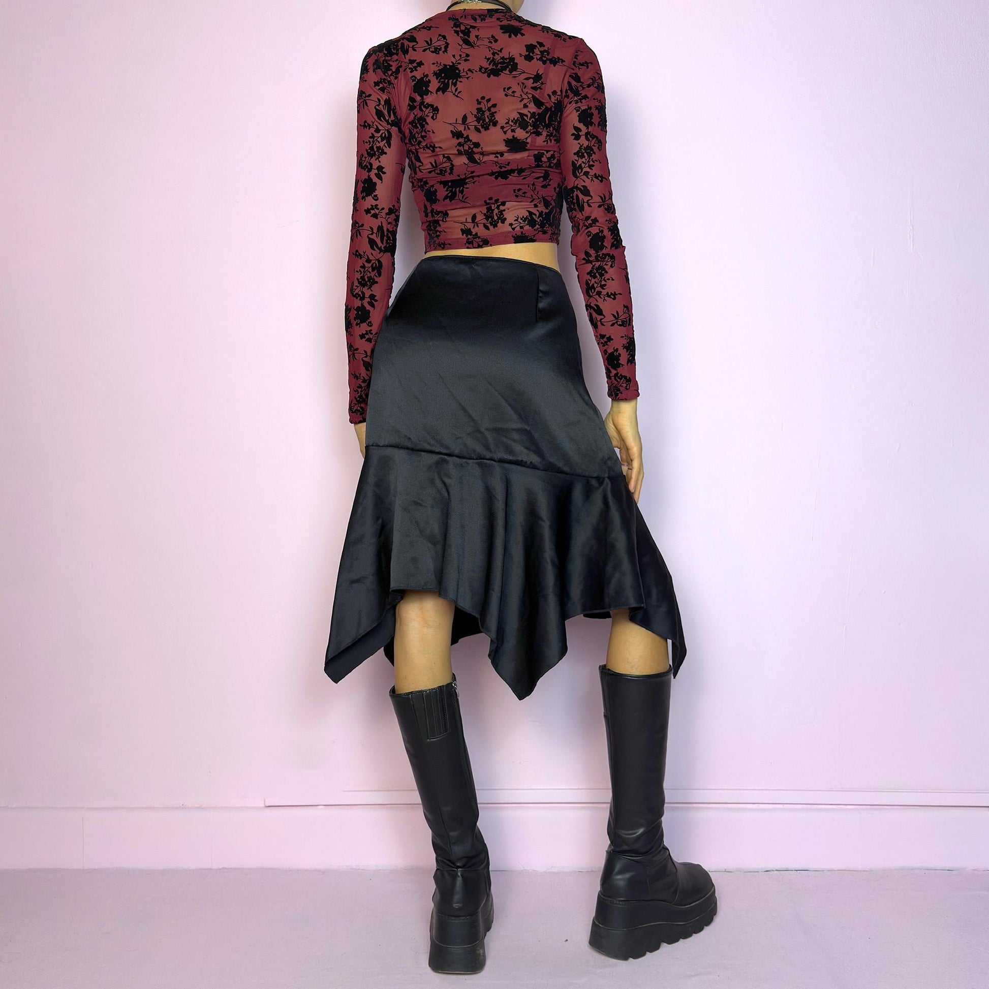The Y2K Black Satin Asymmetric Skirt is a vintage 2000s stylish piece, featuring a satin-like finish with an asymmetrical handkerchief hemline for a dramatic flair and a size zipper closure. Perfect choice for party nights. Adult World Shop
