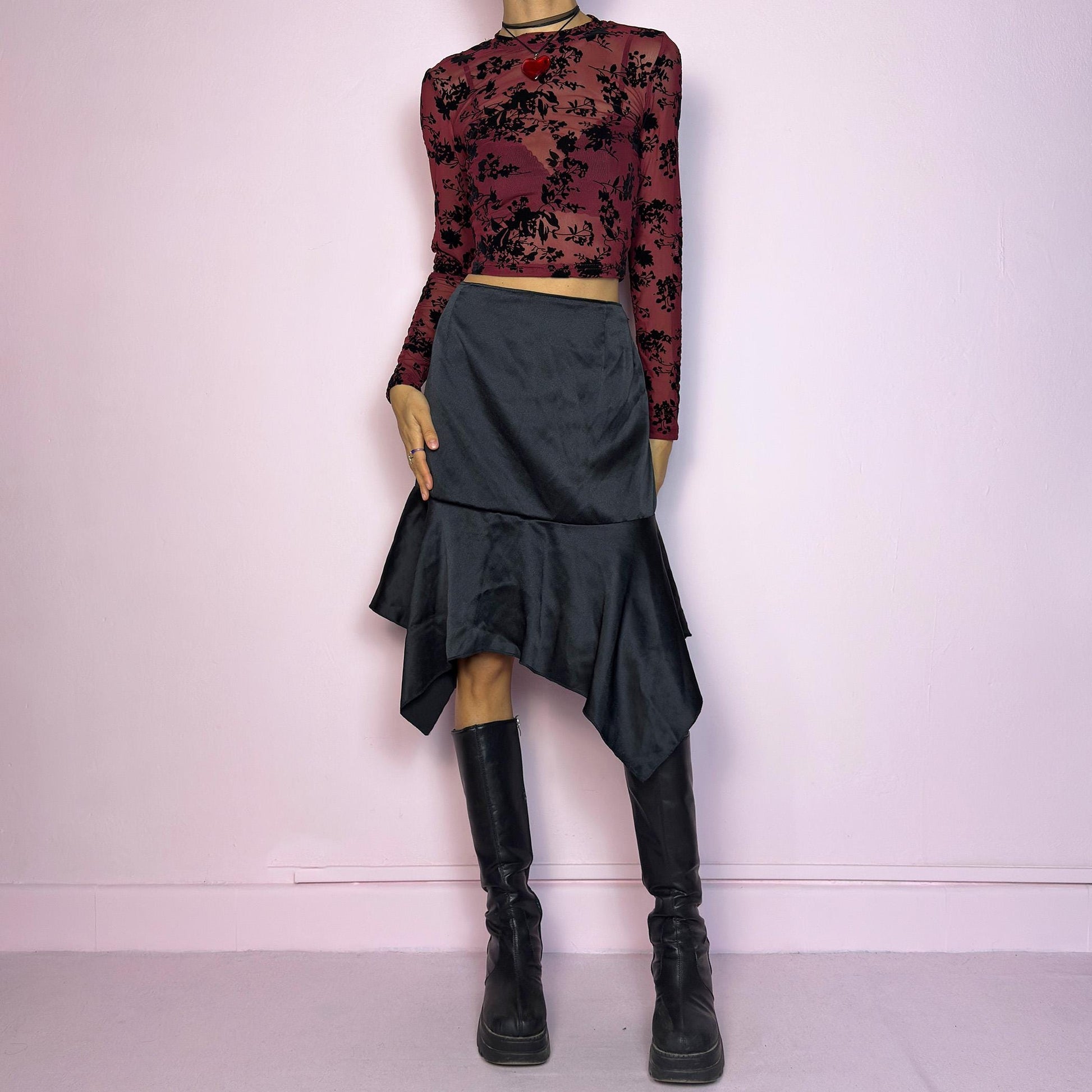 The Y2K Black Satin Asymmetric Skirt is a vintage 2000s stylish piece, featuring a satin-like finish with an asymmetrical handkerchief hemline for a dramatic flair and a size zipper closure. Perfect choice for party nights. Adult World Shop