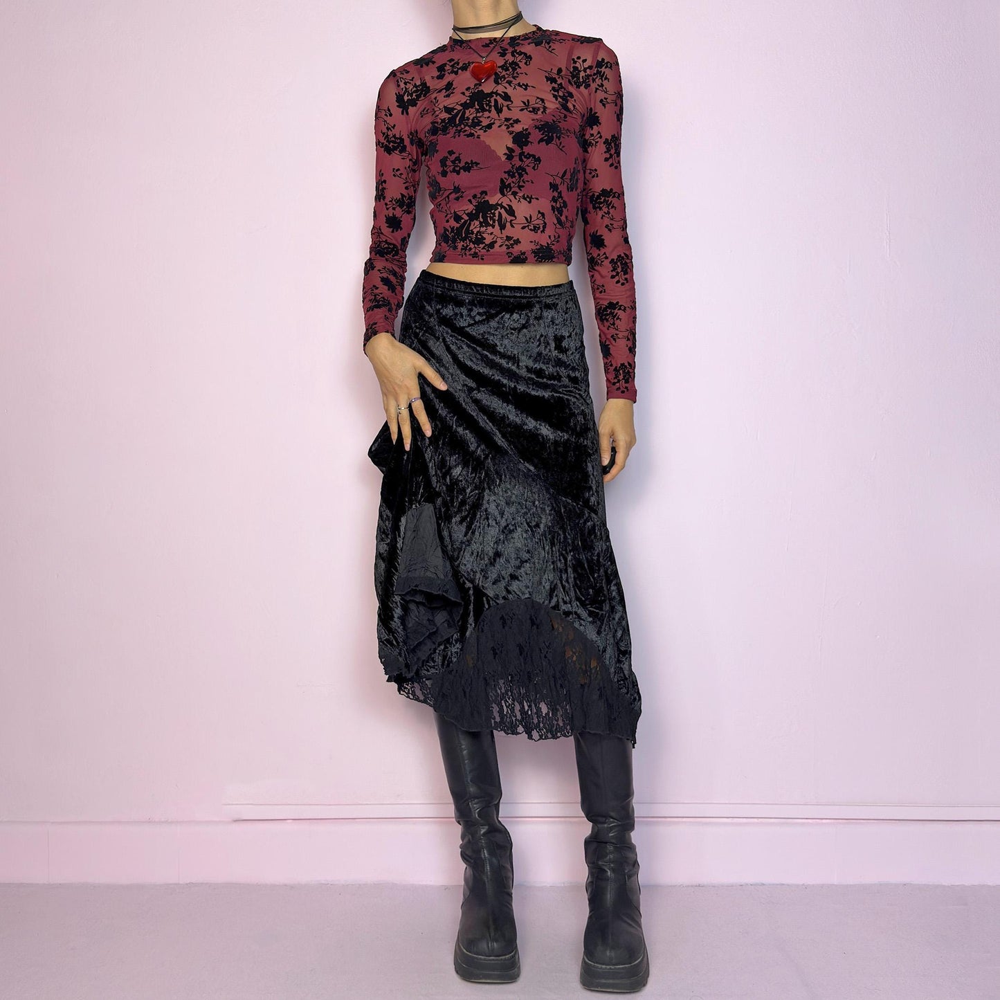 The Vintage 90s Black Velvet Asymmetric Skirt features a velvet fabric with an elegant asymmetrical hemline adorned with lace detailing for a touch of whimsy and an elastic waist. Its romantic and gothic-inspired design. Adult World Shop