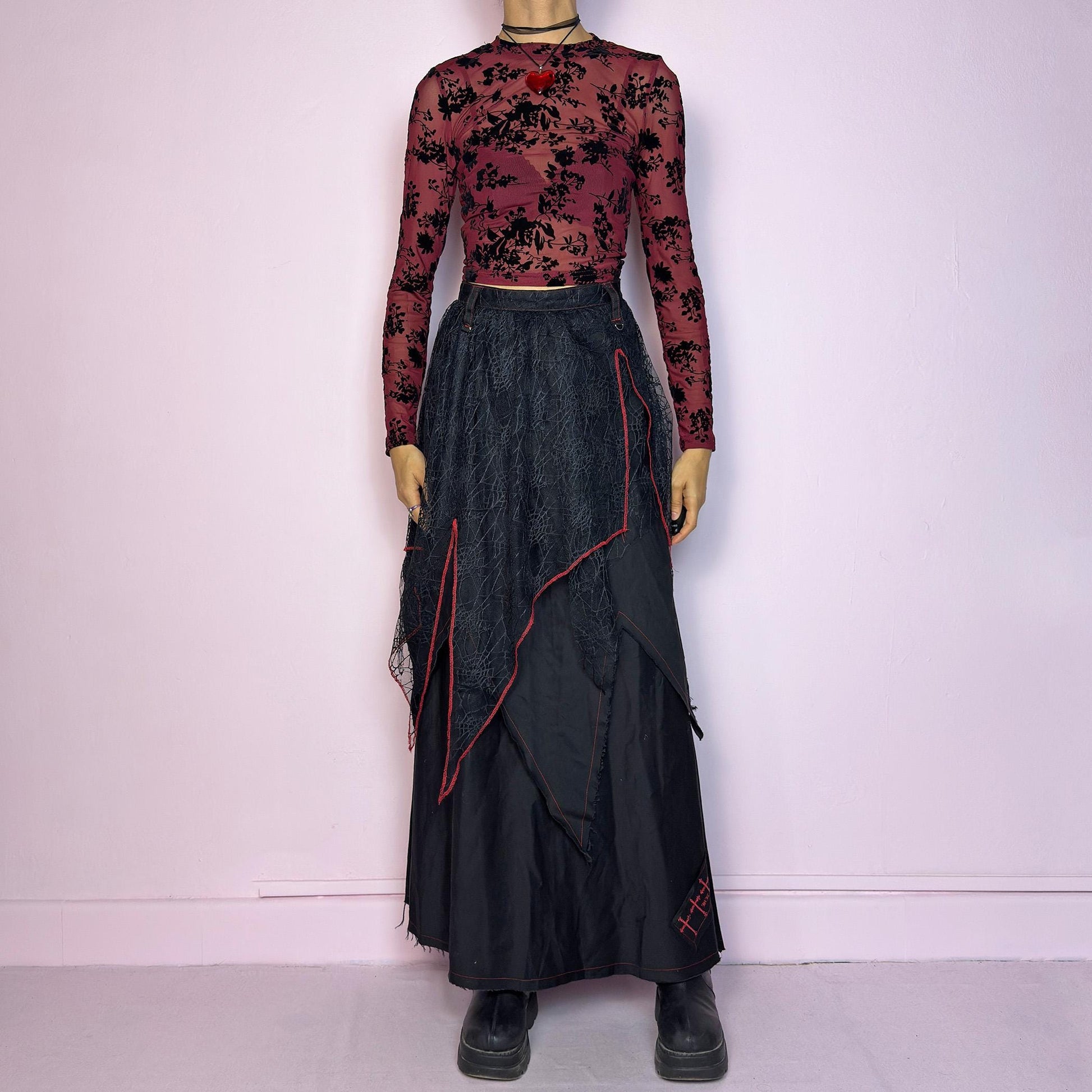 The Black Layered Maxi Skirt is a vintage edgy statement piece crafted by the Japanese punk fashion brand RIGHT? Anarchxism = Kexstation. It features a multi-layered design with mesh web-like overlays, bold red stitching details. Adult World Shop