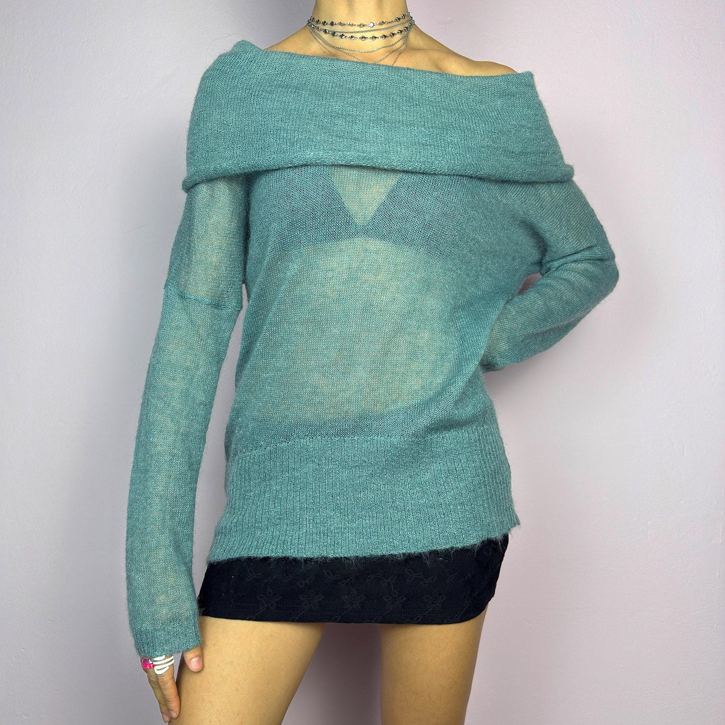 The Y2K Blue Off-Shoulder Sweater is a vintage 2000s cozy and comfy piece made from a mohair, wool, and nylon blend. This soft, semi-sheer sweater features a folded off-shoulder neckline and a muted blue hue. adult world shop