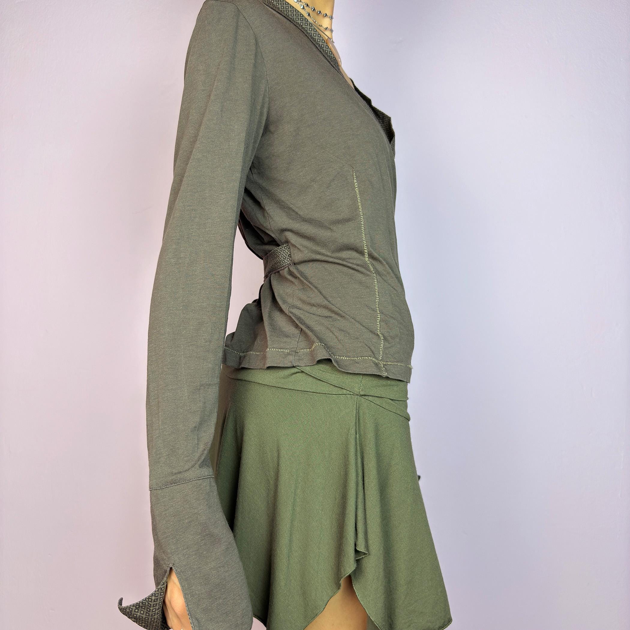 The Y2K Brown Wrap Cop Copine Top is a sleek and minimalist 2000s piece featuring a wrap-tie design with geometric-patterned trim details and flared cuffs. This top is crafted from a stretchy, comfortable fabric. adult world shop