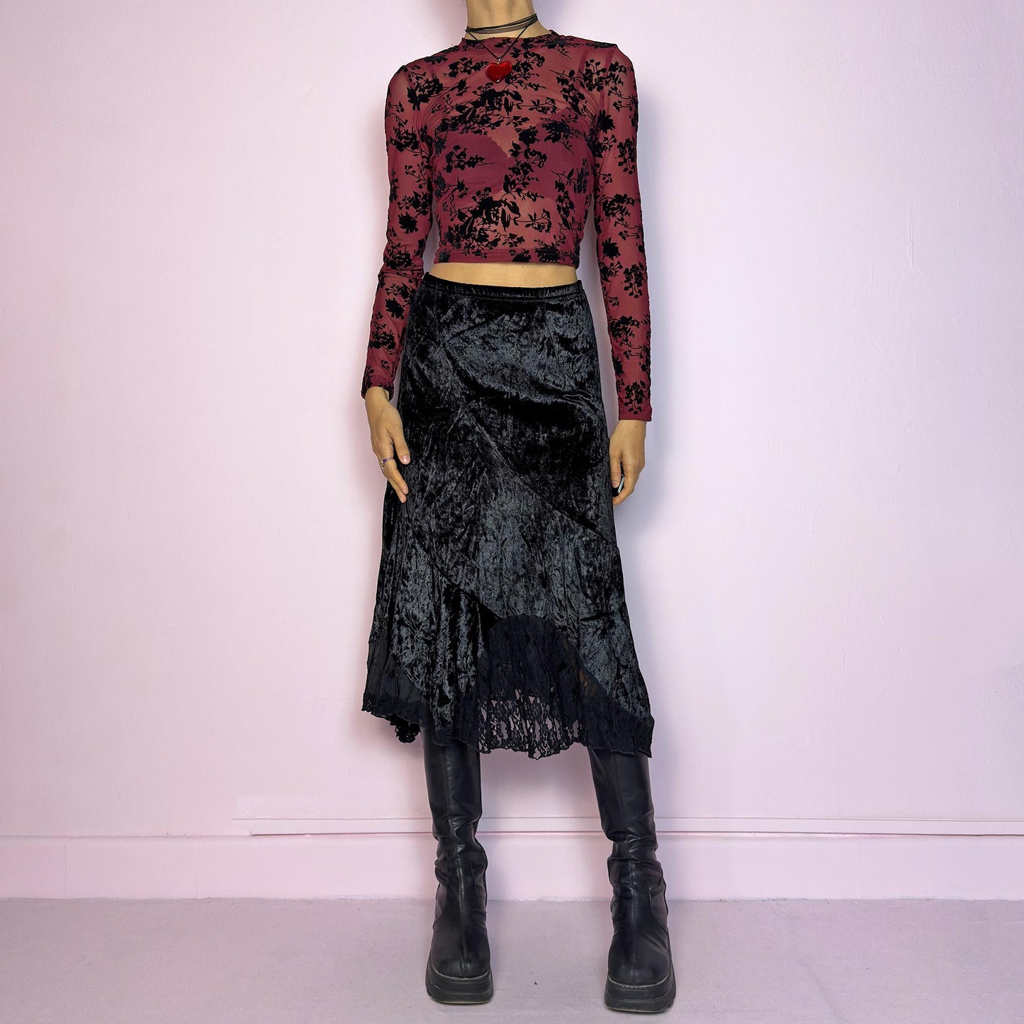 The Vintage 90s Black Velvet Asymmetric Skirt features a velvet fabric with an elegant asymmetrical hemline adorned with lace detailing for a touch of whimsy and an elastic waist. Its romantic and gothic-inspired design. Adult World Shop