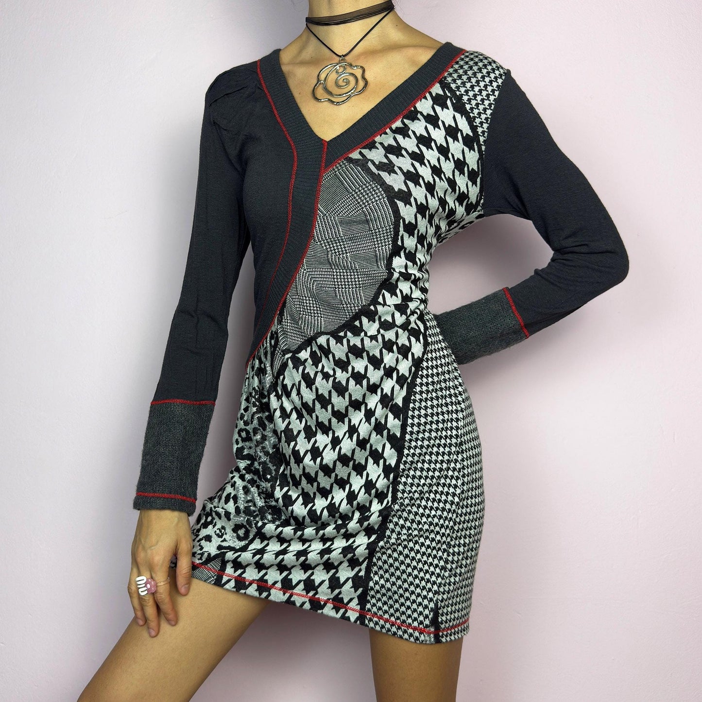 The Y2K Gray Patchwork Mini Dress is a vintage 2000s piece featuring a bold patchwork print with a mix of houndstooth, plaid, and leopard patterns, a V-neckline and long sleeves. The fitted silhouette. adult world shop