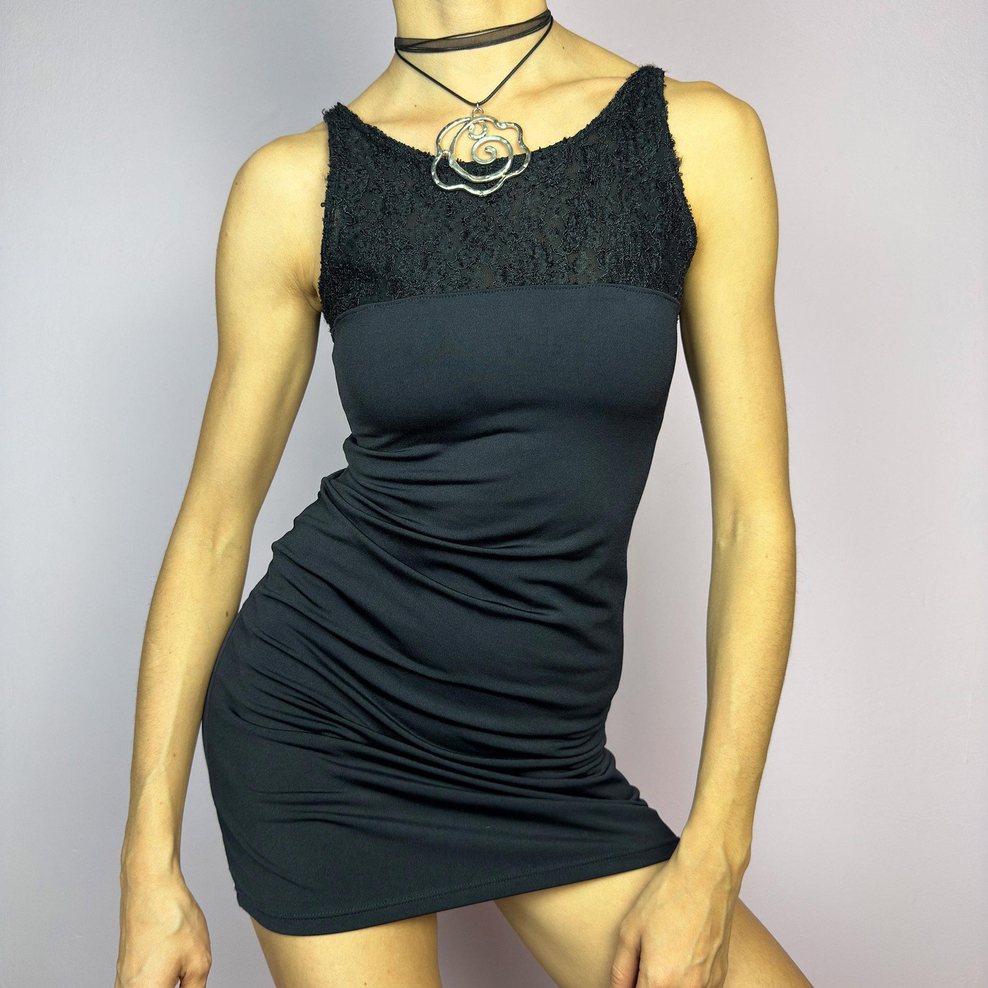 The Y2K Black Bodycon Mini Dress is a vintage 2000s piece featuring a delicate lace panel on the top with a sleek, stretchy fabric for a figure-hugging fit. Perfect for a night-out or party look. adult world shop
