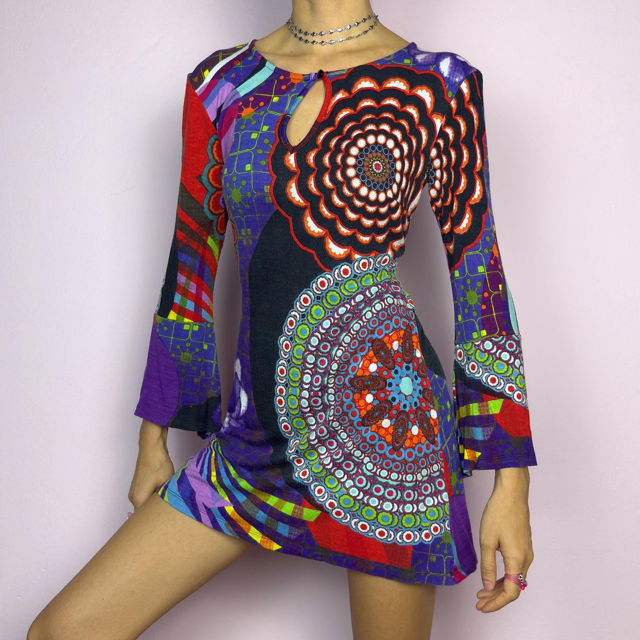 The Y2K Psychedelic Print Mini Dress is a statement 2000s piece, featuring a bold and colorful abstract pattern with a mix of geometric and floral designs and is crafted from a stretchy fabric. adult world shop