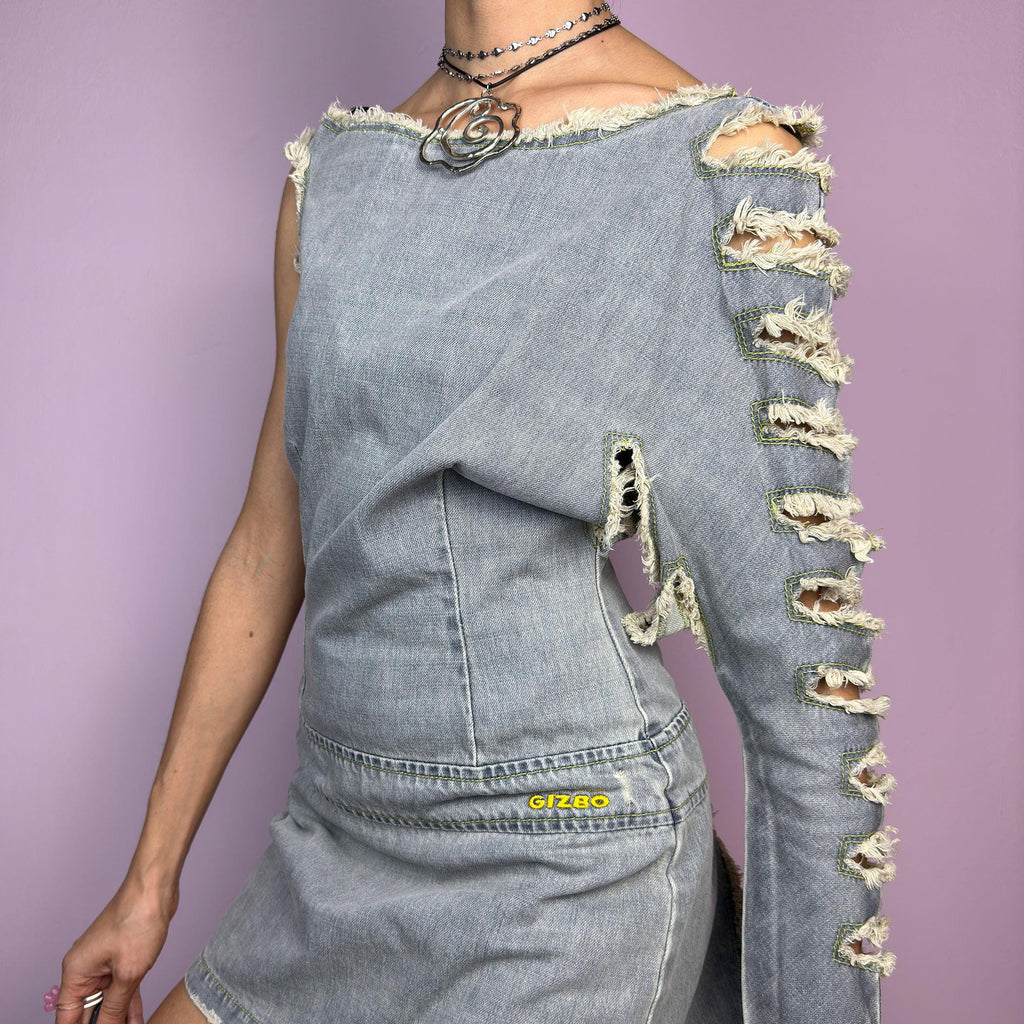 The Y2K Distressed Denim Mini Dress is an edgy statement 2000s piece featuring a raw-cut, asymmetrical design with a structured fit and a side zipper closure. Made from vintage-wash denim, this dress has a deconstructed aesthetic. adult world shop