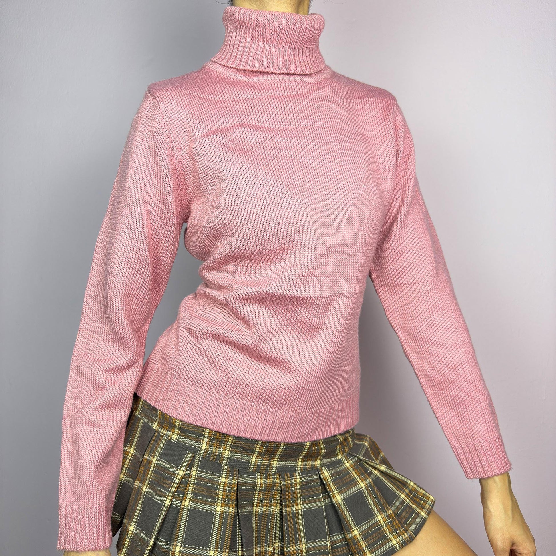 This Y2K Pink Turtleneck Sweater is a cozy 2000s essential with a minimalist vintage aesthetic. Crafted from a soft, knit fabric in a muted pastel pink, it features a classic high turtleneck, a fitted silhouette for a flattering look and long sleeves with ribbed cuffs. Ideal for casual or preppy winter styles. adult world shop