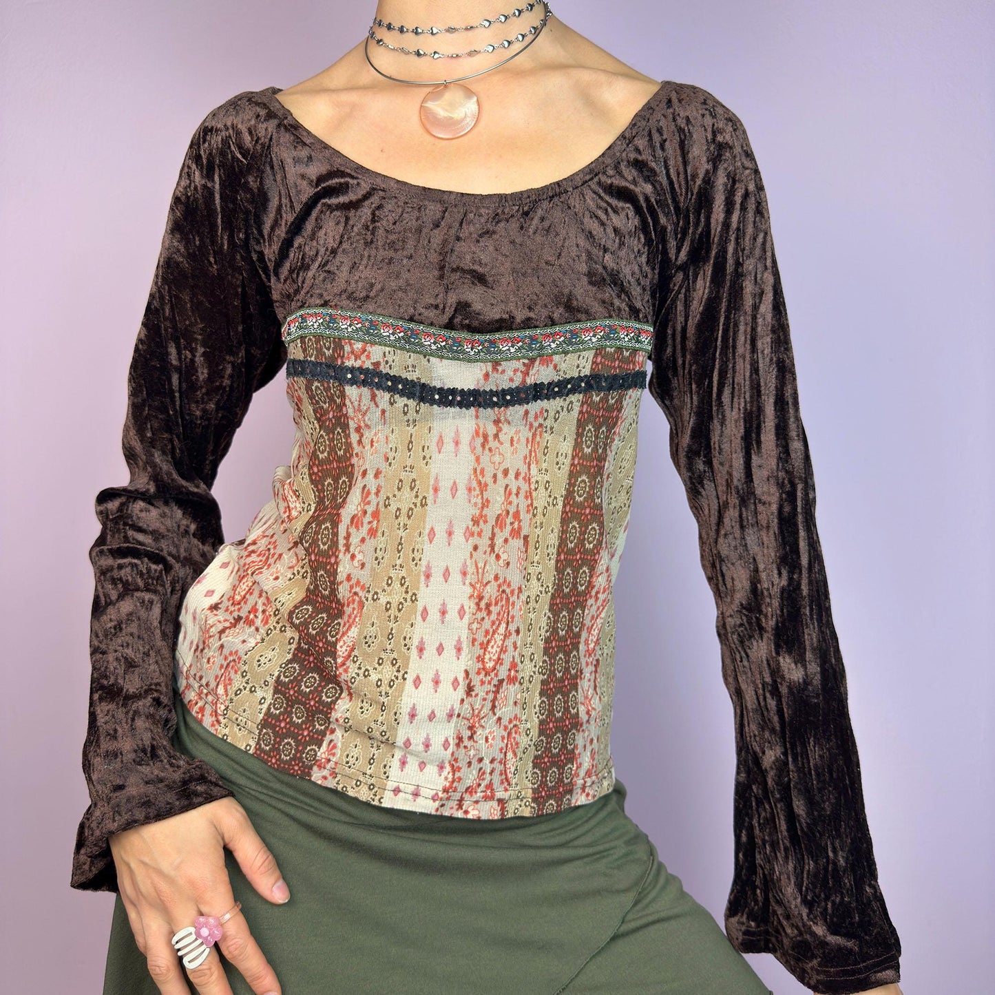 The Y2K Flared Sleeve Mesh Top is a vintage 2000s stretchy piece that combines soft brown velvet bell long sleeves with a printed semi-sheer mesh bodice featuring earthy tones. Perfect for a whimsical inspired look. adult world shop