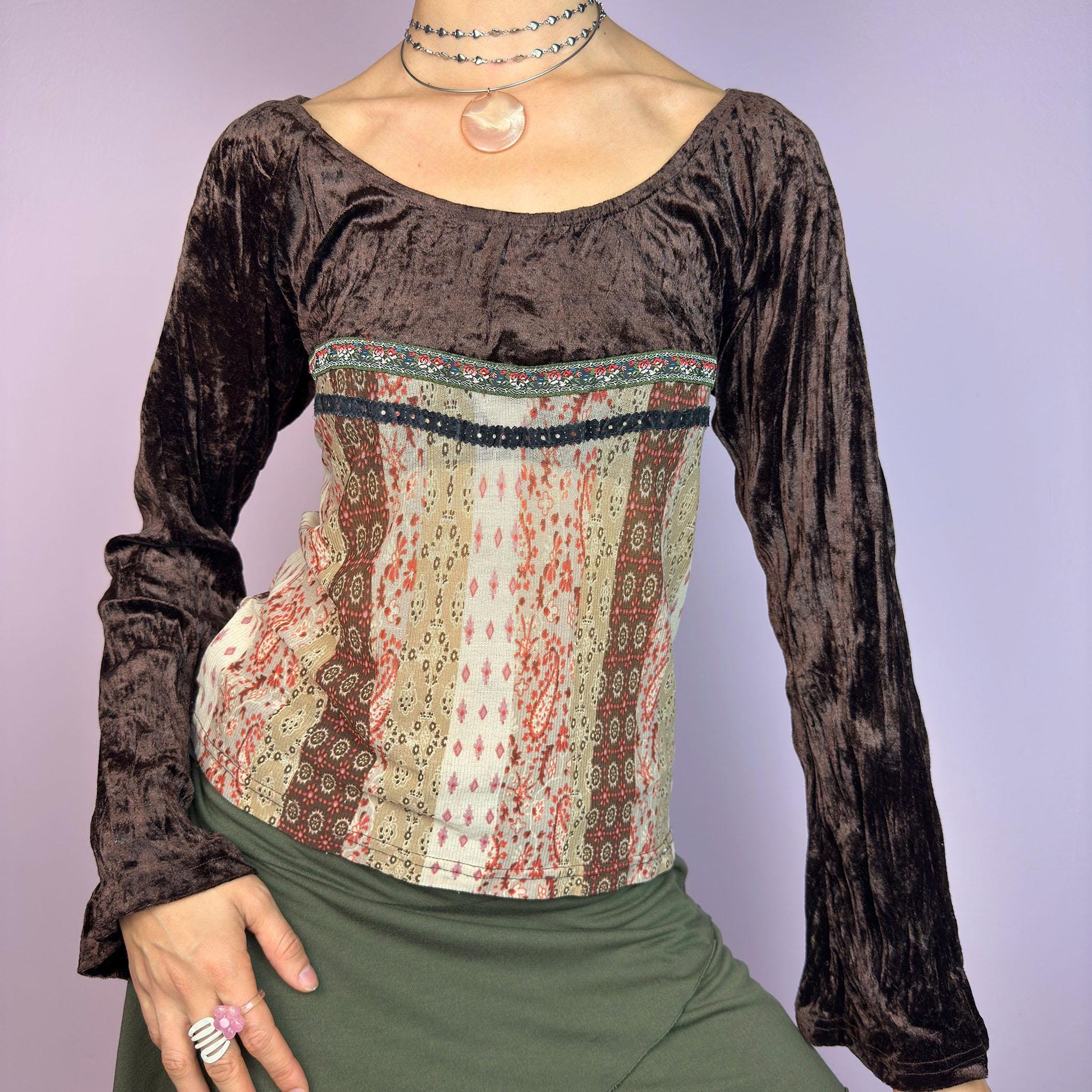 The Y2K Flared Sleeve Mesh Top is a vintage 2000s stretchy piece that combines soft brown velvet bell long sleeves with a printed semi-sheer mesh bodice featuring earthy tones. Perfect for a whimsical inspired look. adult world shop