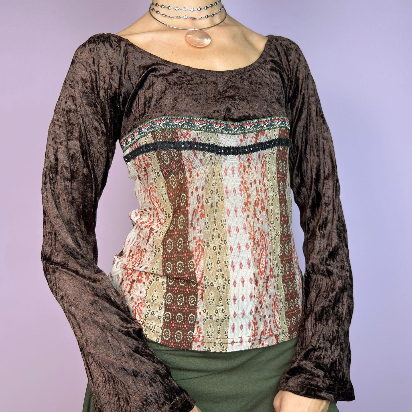 The Y2K Flared Sleeve Mesh Top is a vintage 2000s stretchy piece that combines soft brown velvet bell long sleeves with a printed semi-sheer mesh bodice featuring earthy tones. Perfect for a whimsical inspired look. adult world shop
