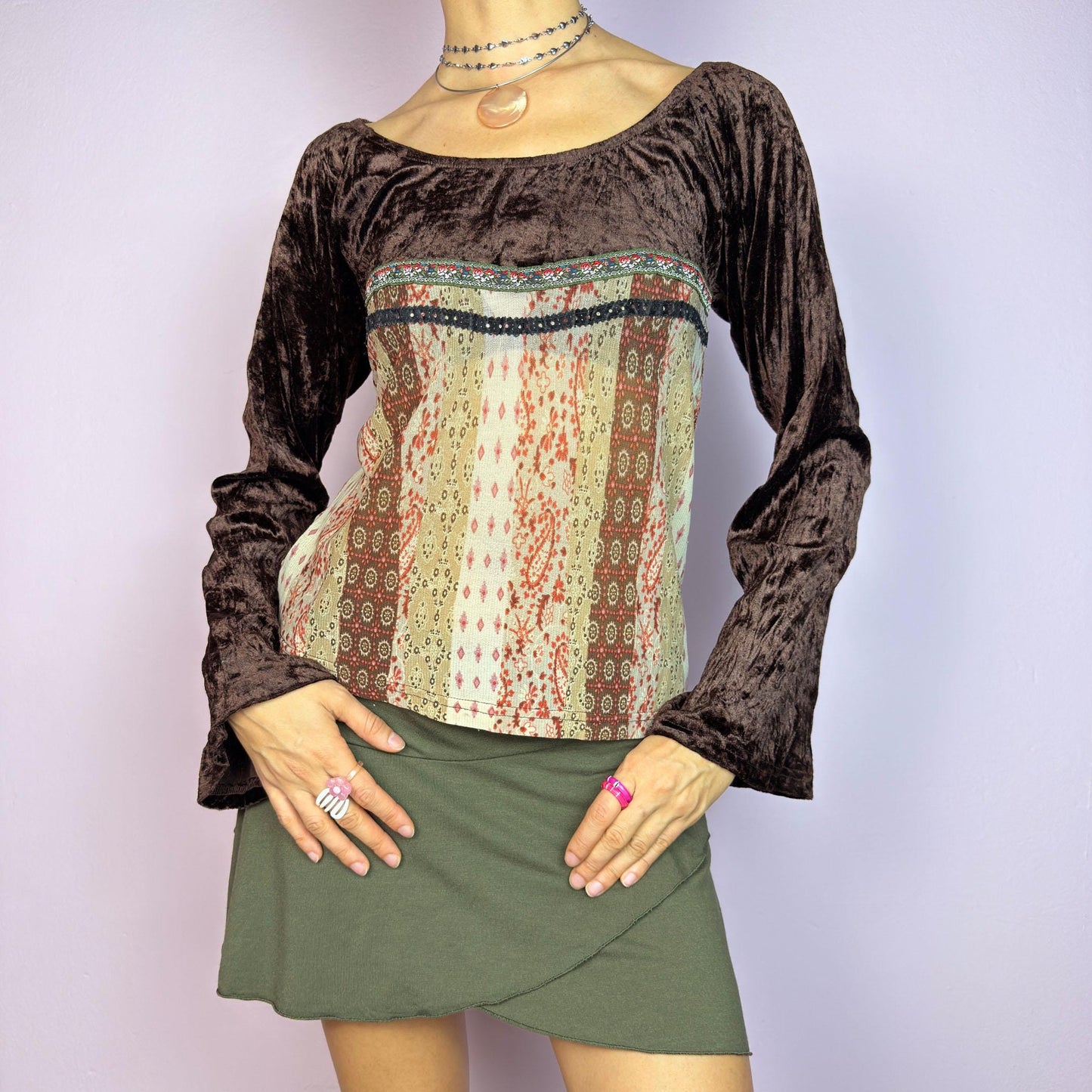 The Y2K Flared Sleeve Mesh Top is a vintage 2000s stretchy piece that combines soft brown velvet bell long sleeves with a printed semi-sheer mesh bodice featuring earthy tones. Perfect for a whimsical inspired look. adult world shop