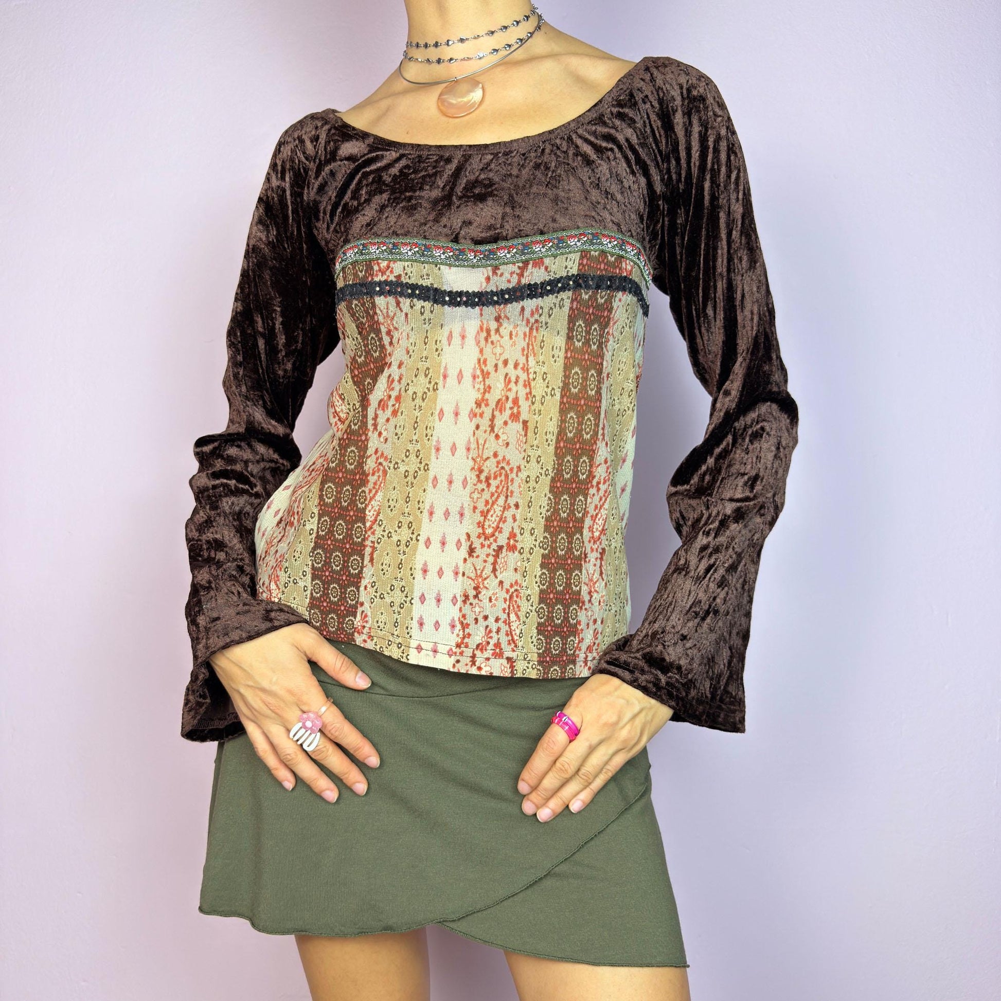 The Y2K Flared Sleeve Mesh Top is a vintage 2000s stretchy piece that combines soft brown velvet bell long sleeves with a printed semi-sheer mesh bodice featuring earthy tones. Perfect for a whimsical inspired look. adult world shop
