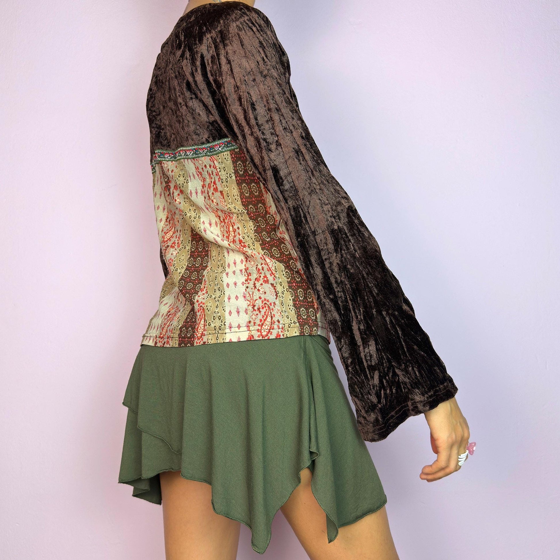 The Y2K Flared Sleeve Mesh Top is a vintage 2000s stretchy piece that combines soft brown velvet bell long sleeves with a printed semi-sheer mesh bodice featuring earthy tones. Perfect for a whimsical inspired look. adult world shop