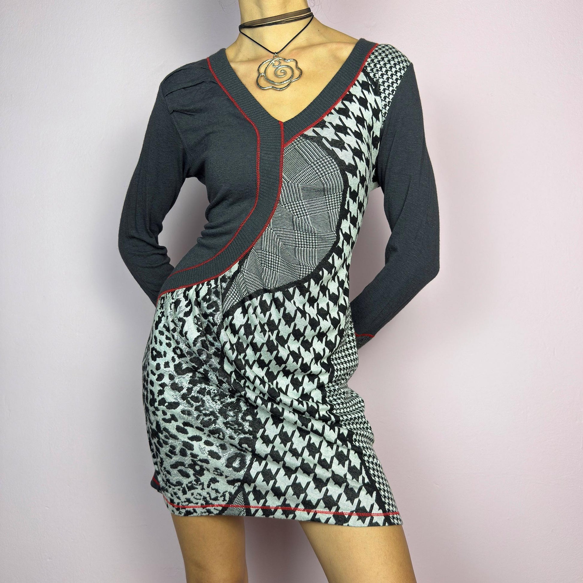 The Y2K Gray Patchwork Mini Dress is a vintage 2000s piece featuring a bold patchwork print with a mix of houndstooth, plaid, and leopard patterns, a V-neckline and long sleeves. The fitted silhouette. adult world shop
