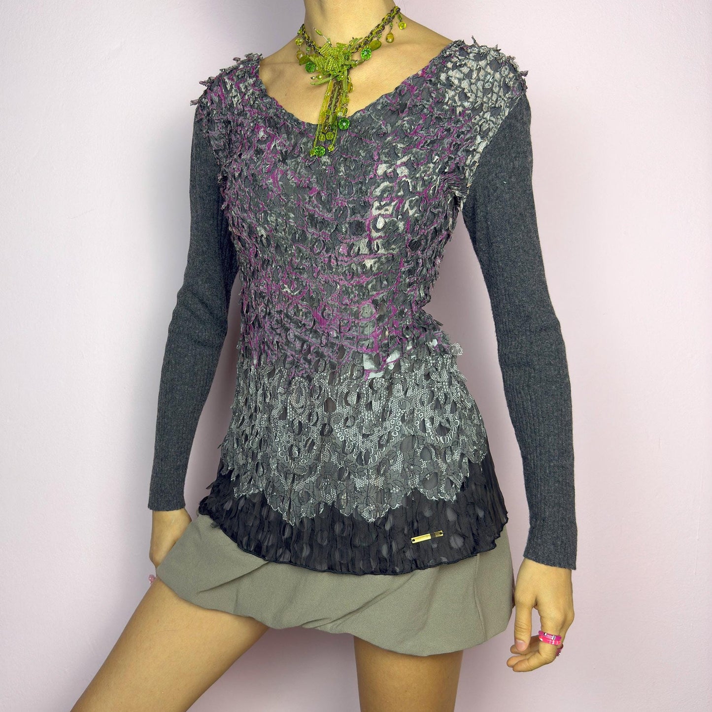 The Y2K Gray Crinkled Textured Top is a vintage 2000s piece by designer Roberto Verino, featuring a unique sheer overlay with delicate cut-out details that create a dimensional, deconstructed look. The long knit sleeves contrast beautifully with the intricate textures, adding depth to this stretchy fit design. A standout piece for those who love avant-garde fashion. adult world shop