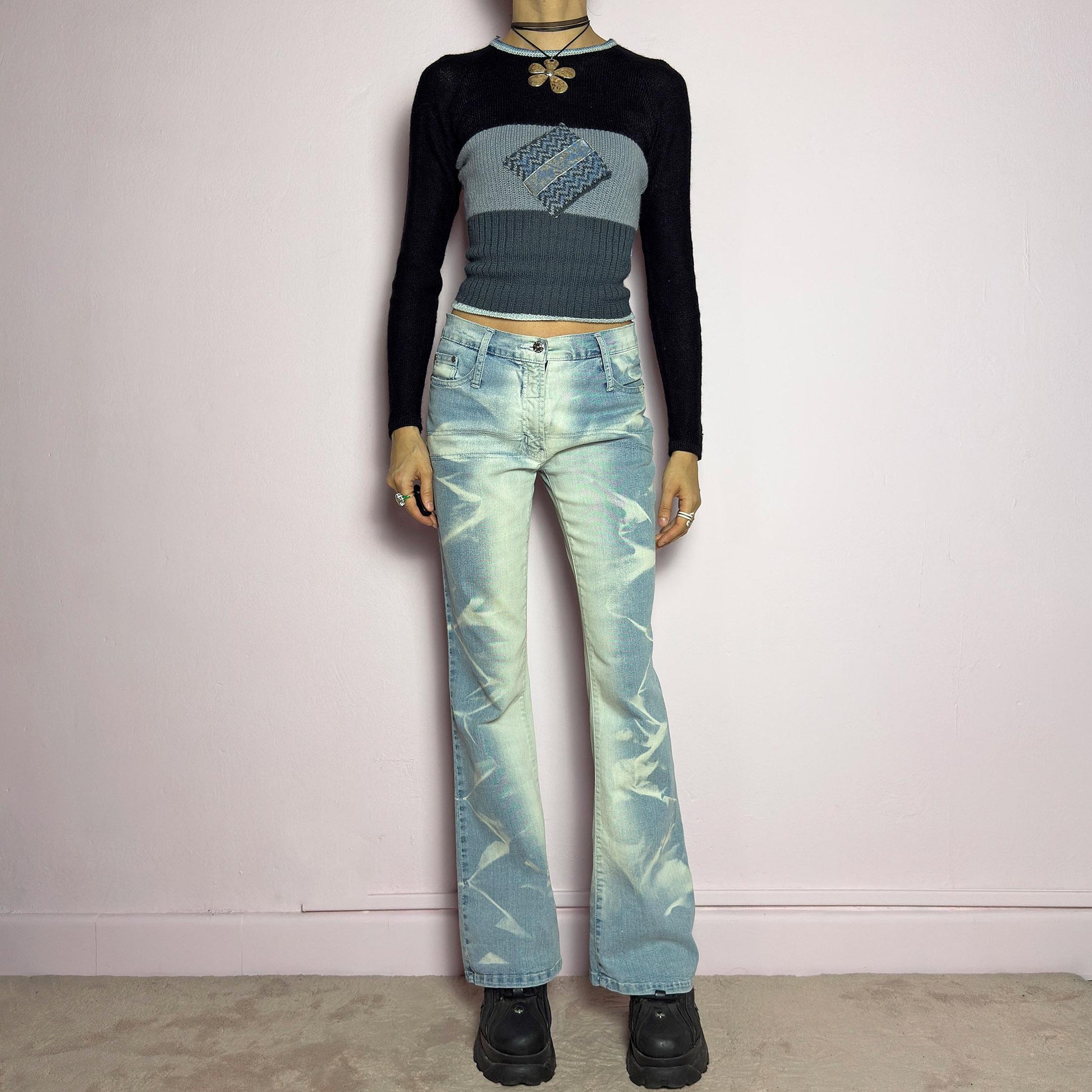 The Y2K Bleached Flare Jeans are a vintage 2000s statement piece featuring a light-wash denim with a bold bleached abstract pattern for a deconstructed, experimental look. Designed with a flattering mid-rise fit, flared legs, button and zipper closure, and pockets, these jeans are a perfect blend of edgy and playful aesthetics. Ideal for standout casual outfits. adult world shop