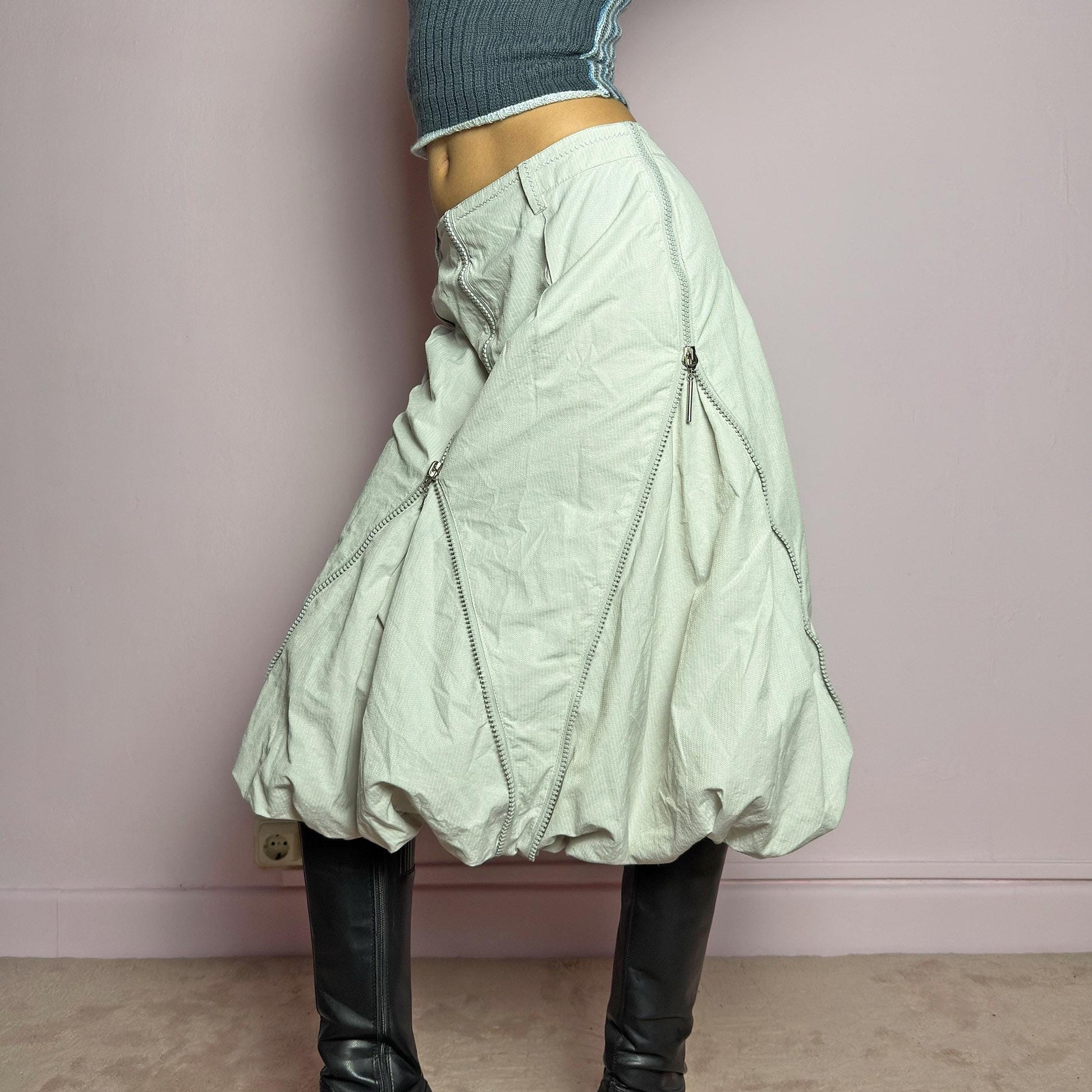 The Y2K Gray Bubble Midi Skirt is a futuristic statement 2000s piece featuring a voluminous bubble silhouette with multiple zipper details that create a dynamic, adjustable shape. Designed with a structured high-rise fit, and a side zipper closure, this skirt is perfect for bold streetwear outfits. adult world shop