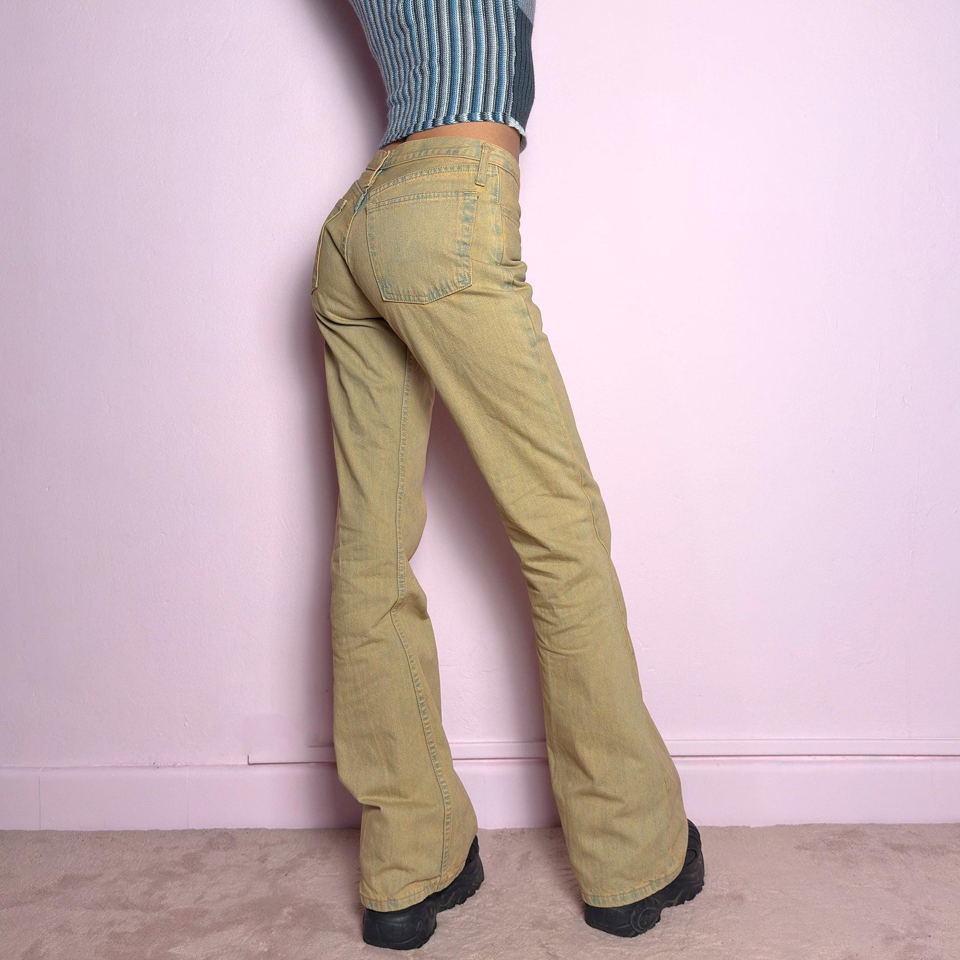 The Y2K Low-Rise Flare Jeans are a vintage 2000s staple featuring a structured denim fabric in a muted earthy tone with a slightly washed effect. Designed with a flattering low-rise fit, button closure, pockets and a flared leg that creates a sleek silhouette, these jeans are perfect for casual outfits. adult world shop